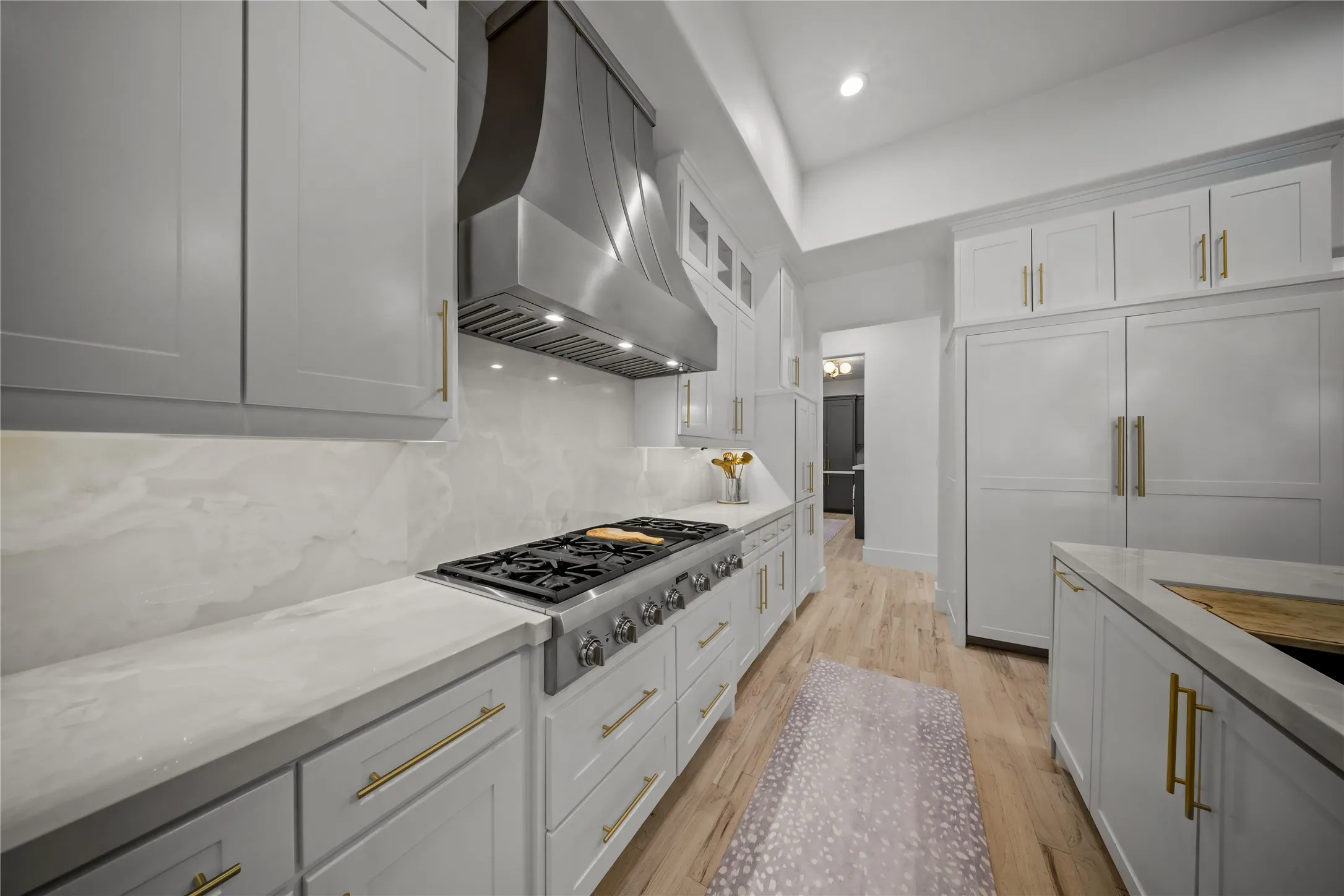 New vent hood with 6 gas burners, double ovens, custom cabinetry, and many built-in features.
