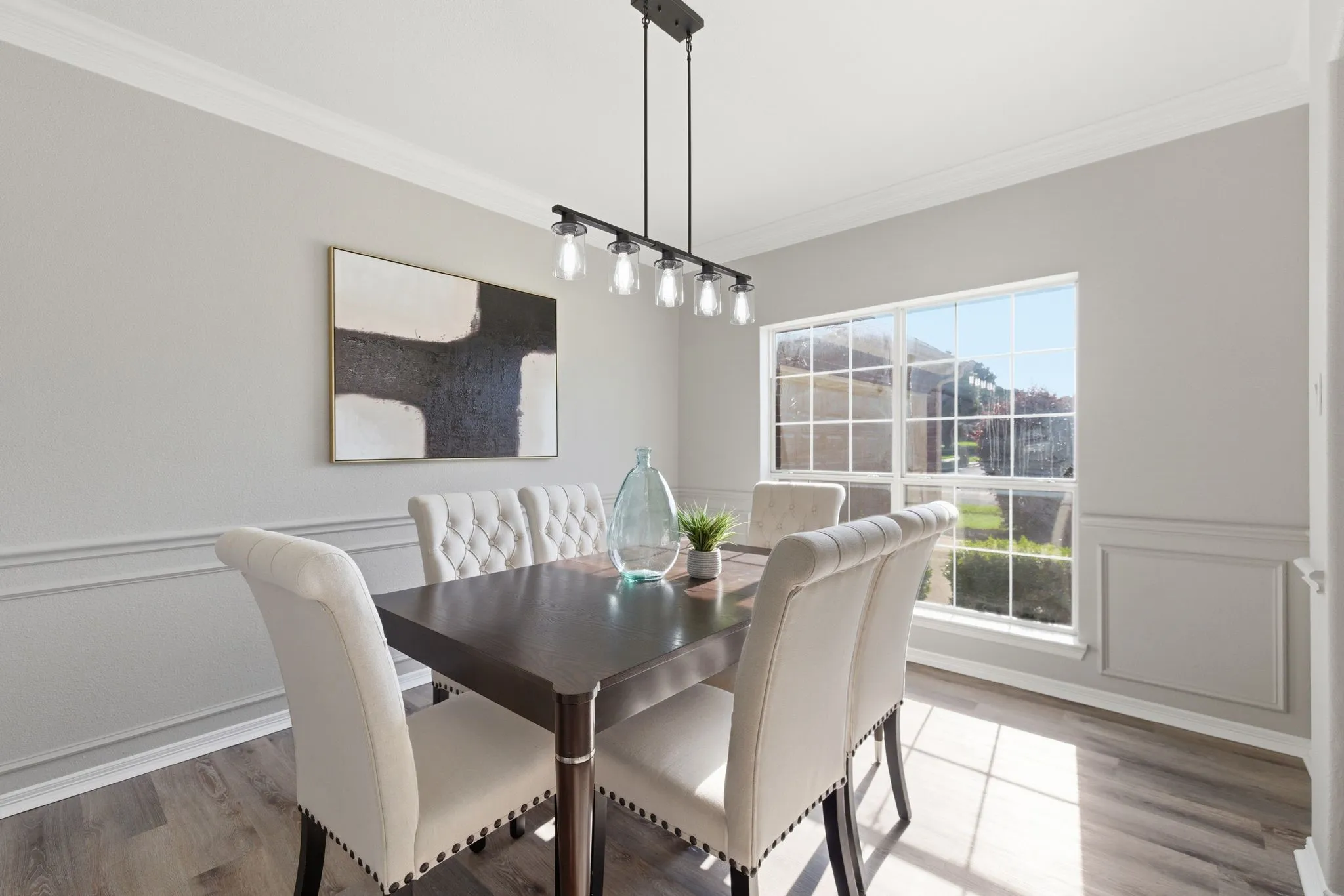 Dining area featuring wood-finish flooring and crown molding