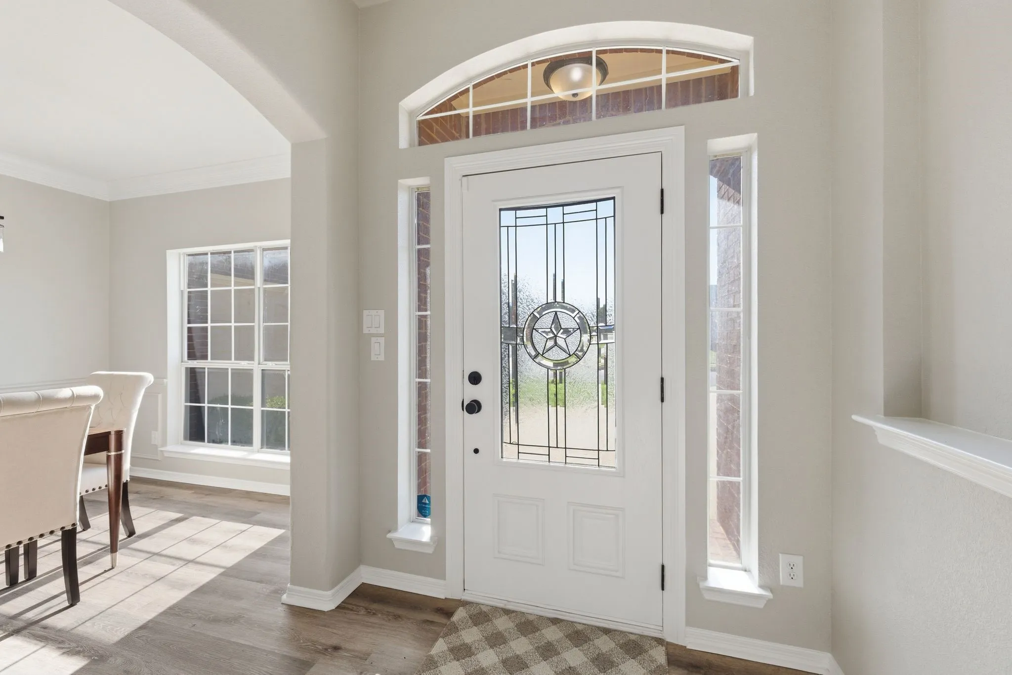 Entryway featuring a white door with a leaded glass insert, arched transom window, and side lite windows