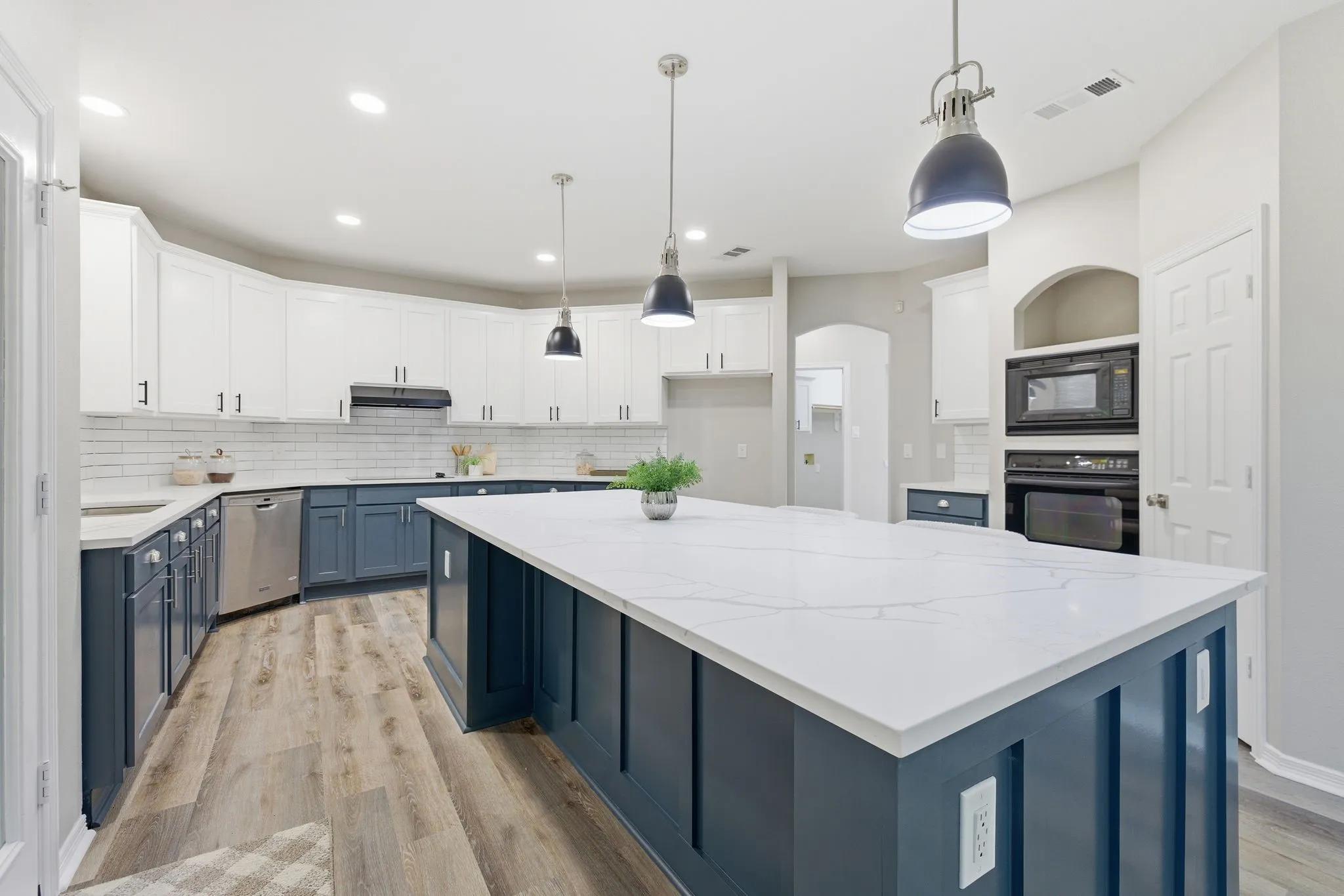 Central kitchen island with a white solid surface countertop and blue paneled base