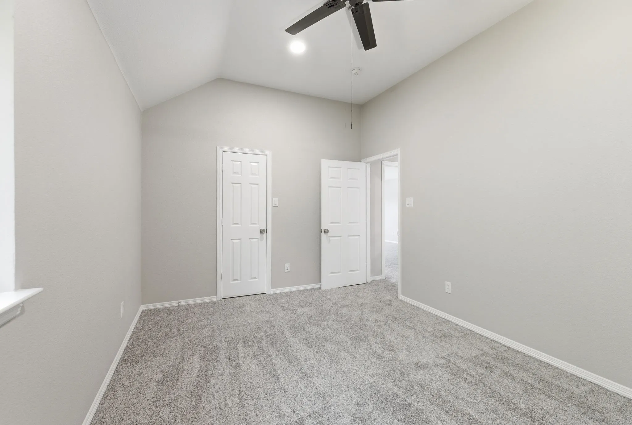 Vaulted ceiling room with gray carpeting and light gray walls