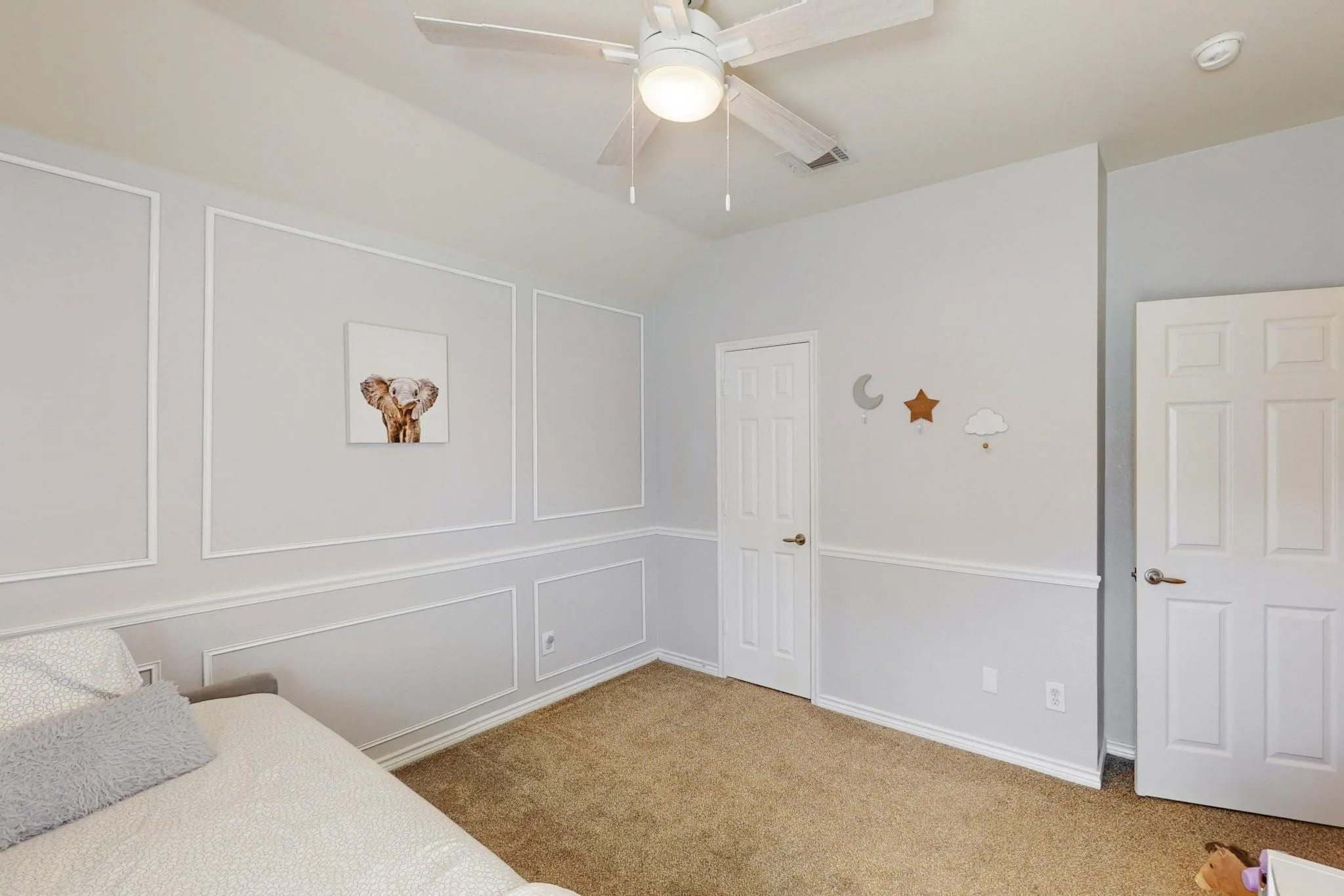 Neutral wall paneling detail, ceiling fan with integrated lighting, and neutral carpet flooring