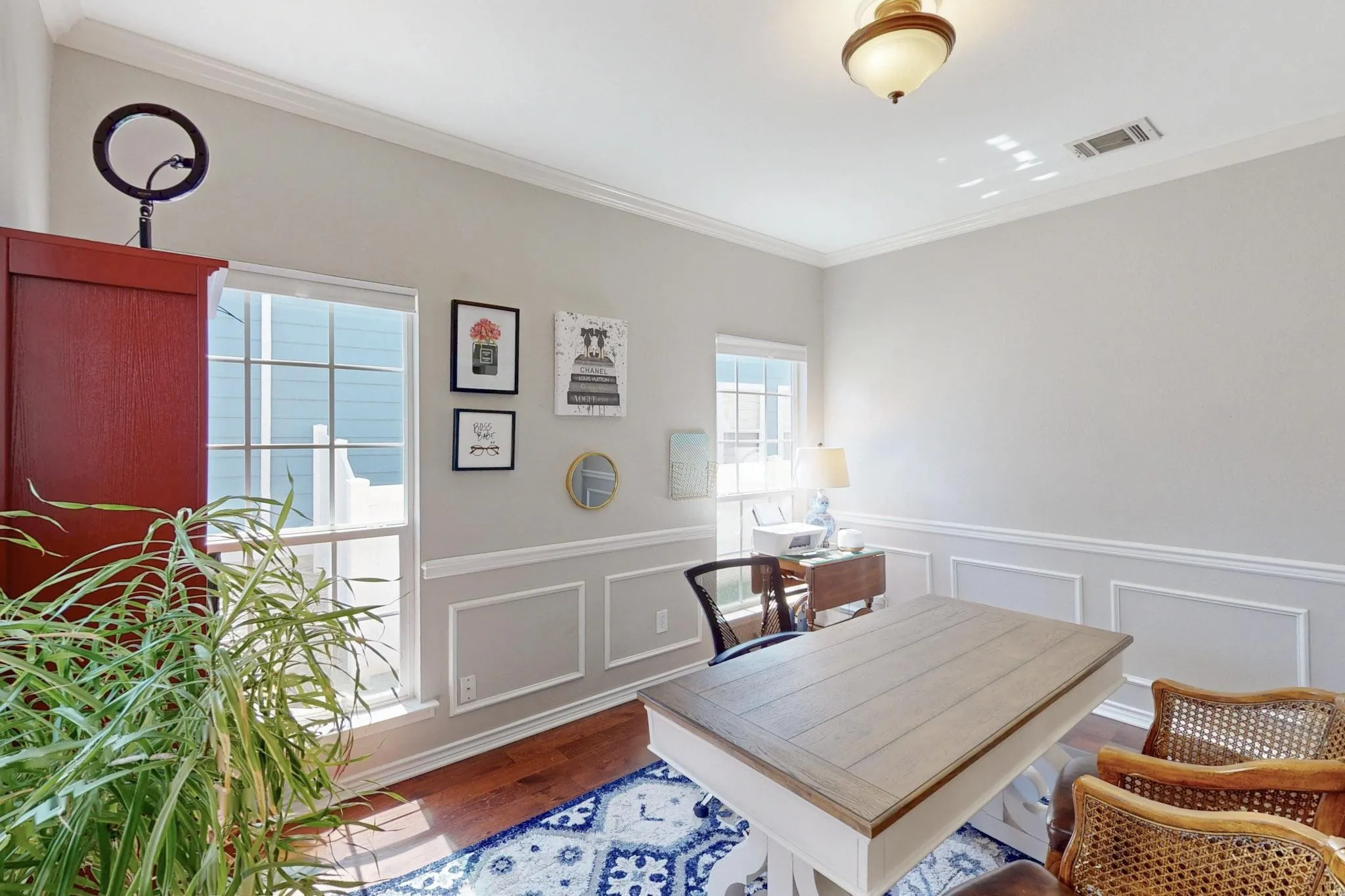 Hardwood flooring, painted walls with wainscoting, crown molding, and a semi-flush mount ceiling fixture
