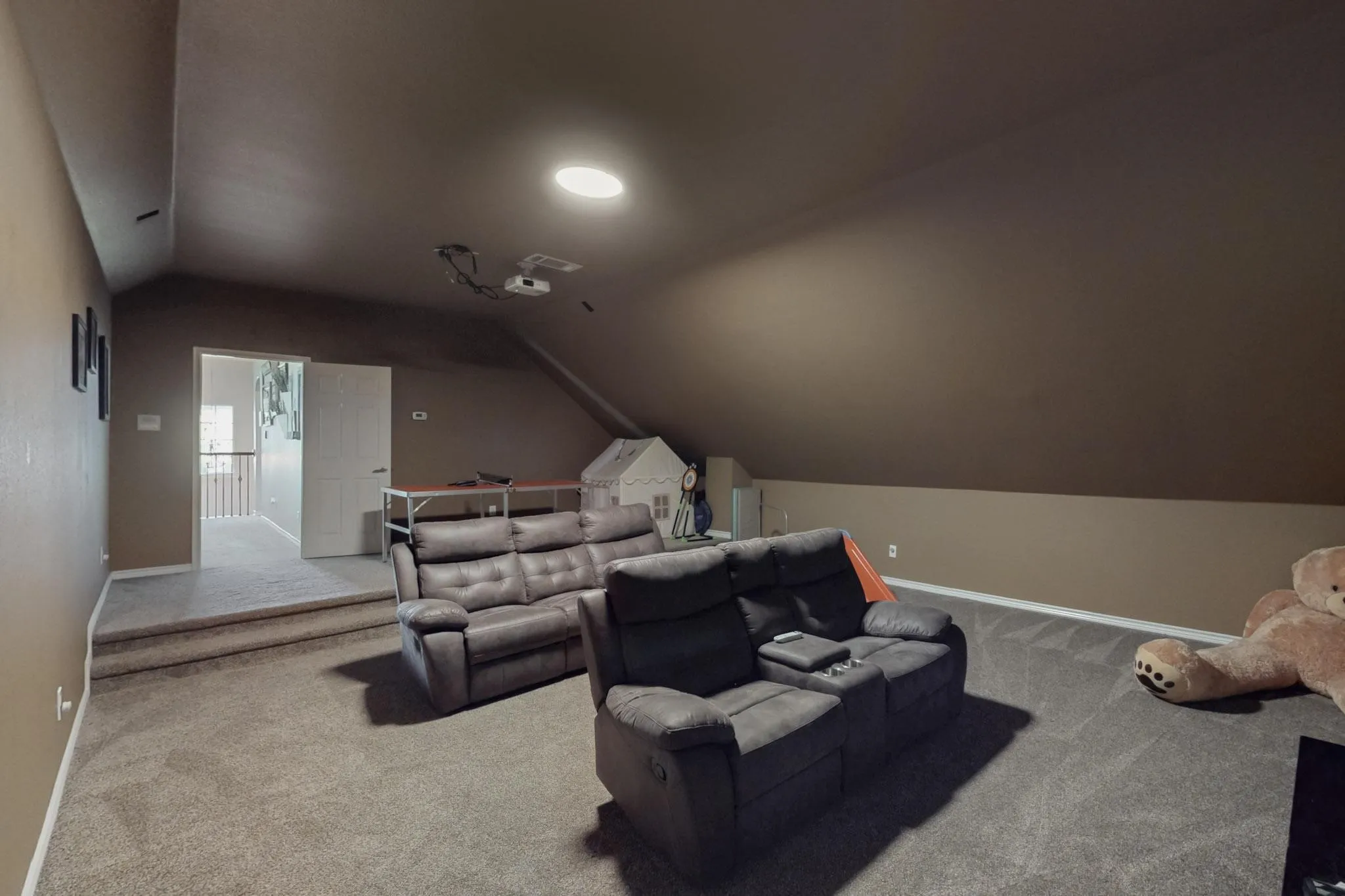 Carpeted room with a stepped entry and sloped ceilings