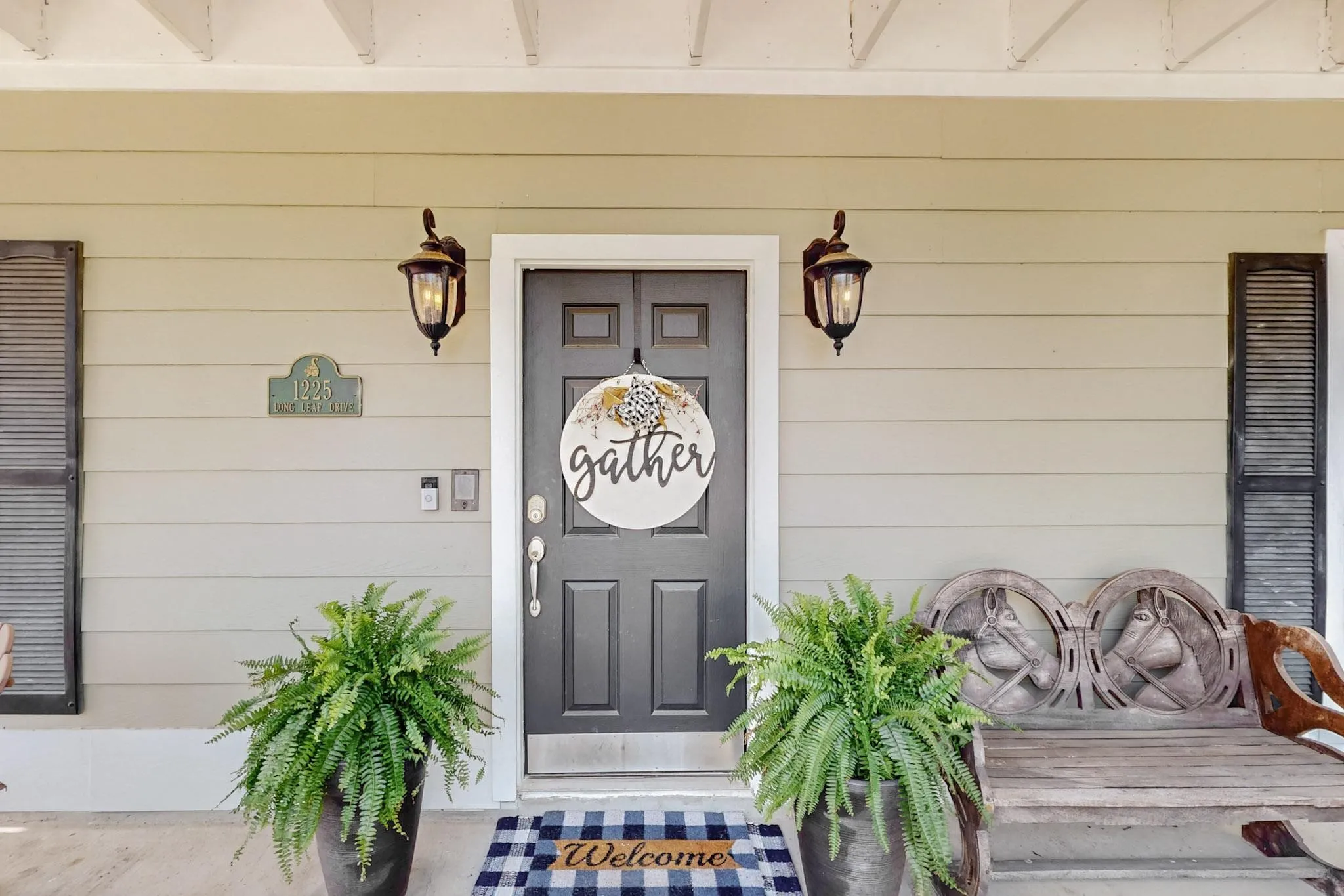 Front entry with a paneled door, two exterior wall lanterns, and horizontal siding