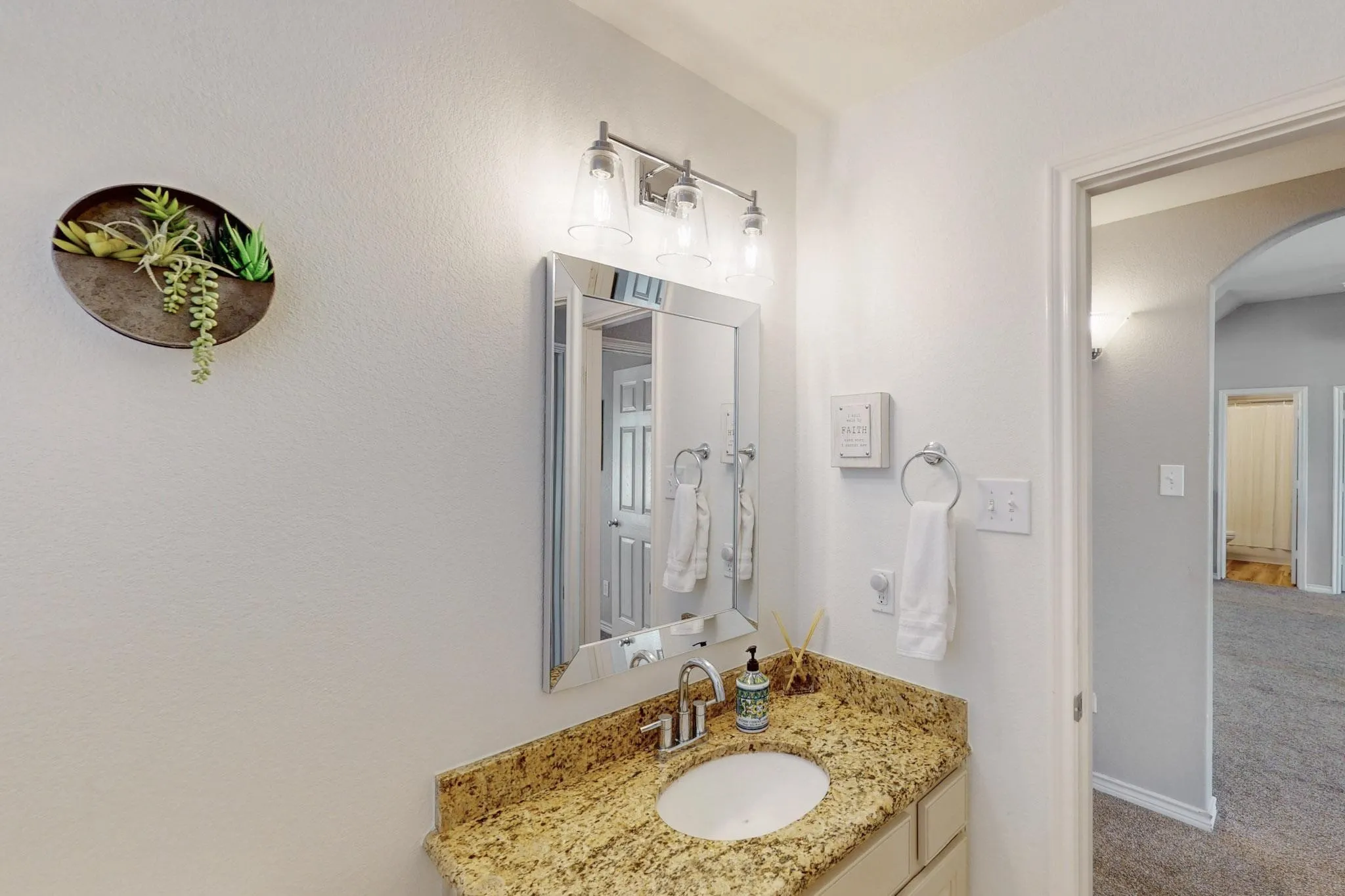 Vanity featuring a polished granite countertop, undermount sink, and chrome faucet
