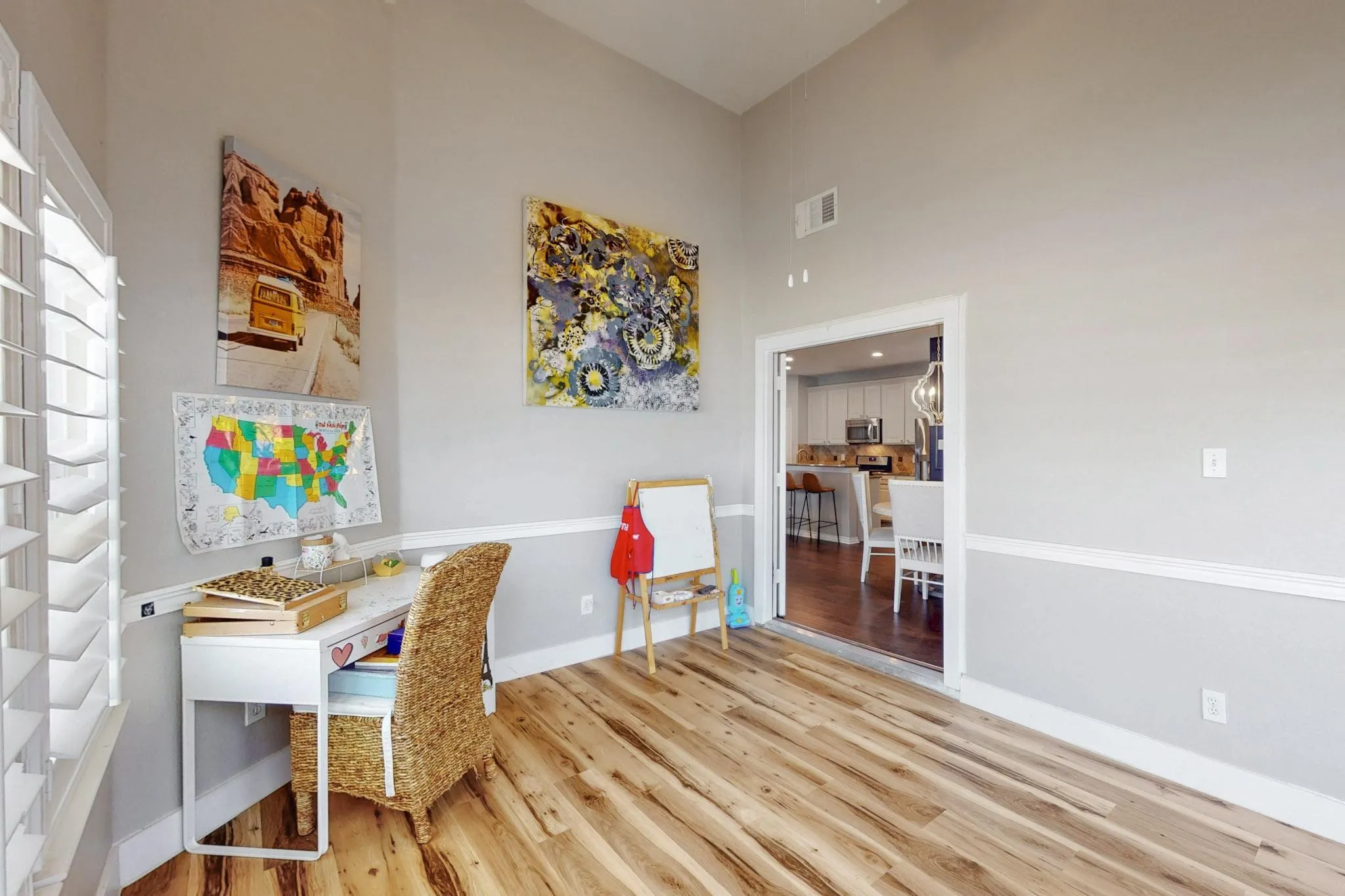 Vaulted ceiling, wood-finish flooring, plantation shutters, picture rail molding, and a wide interior doorway