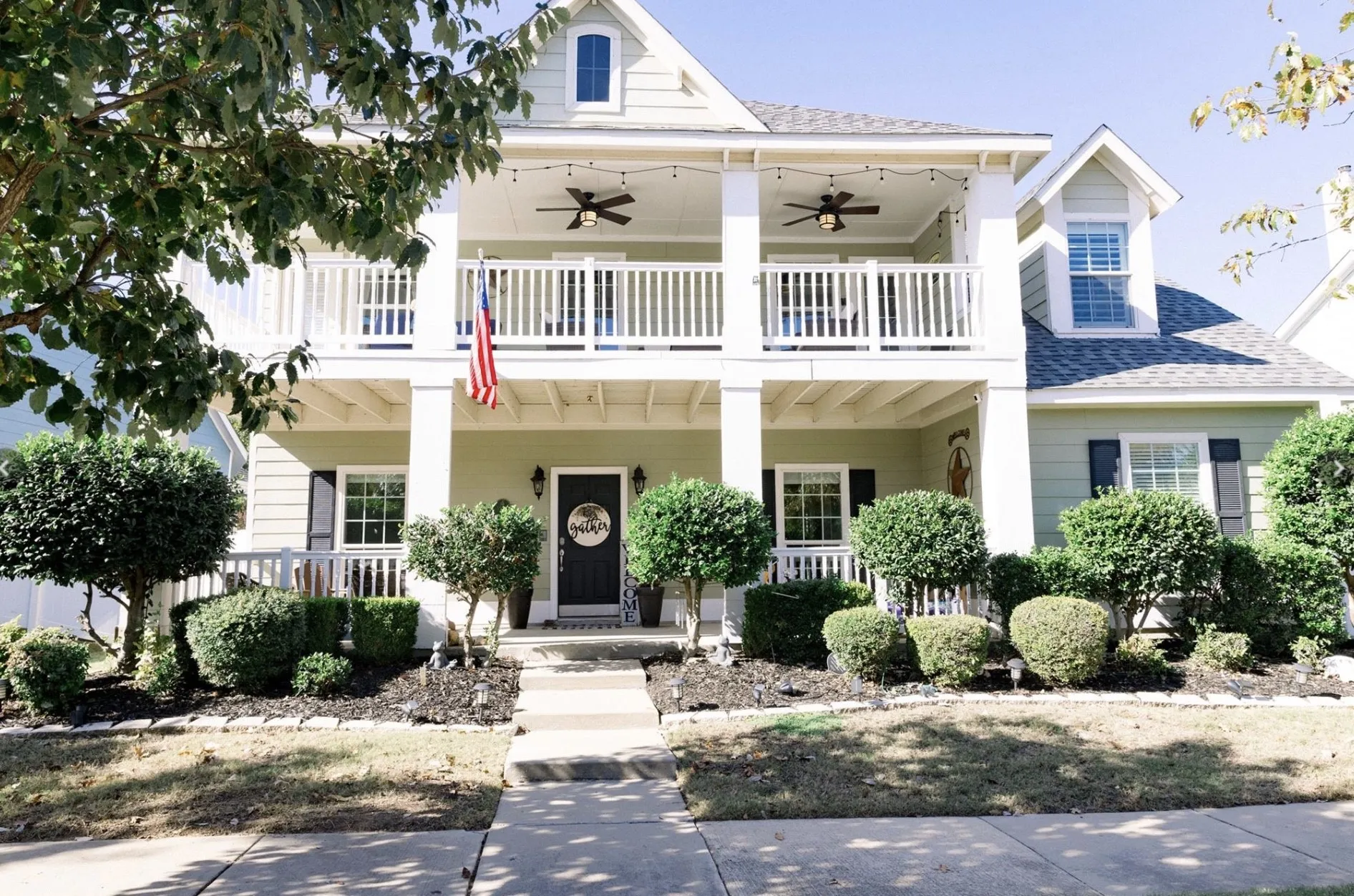 Two-story residence featuring a covered front porch and an upper-level balcony