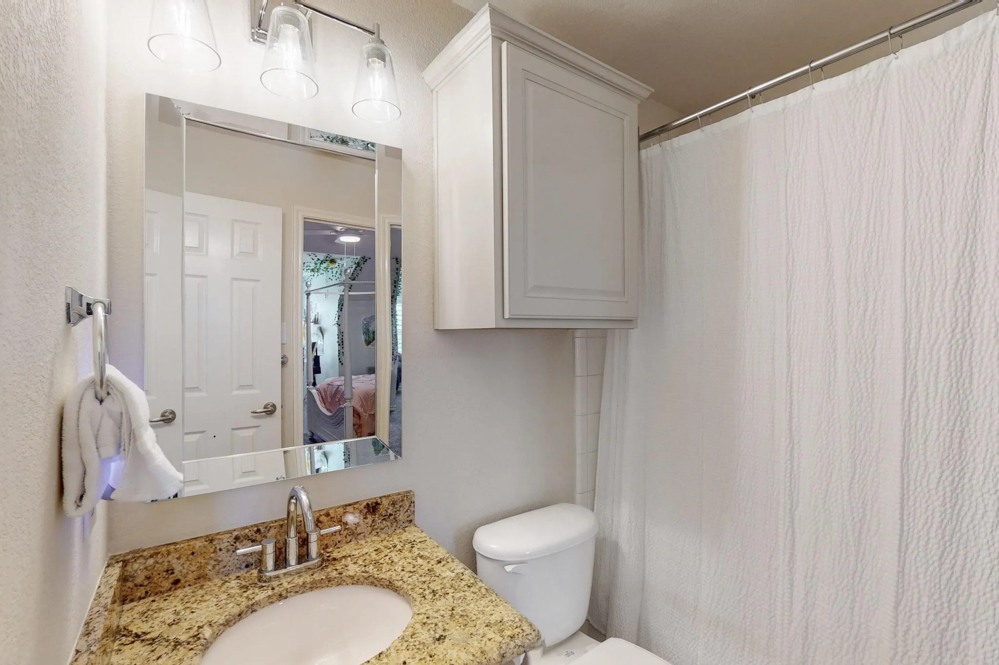 Bathroom with a vanity featuring a beige-toned countertop, an undermount sink, and a chrome faucet