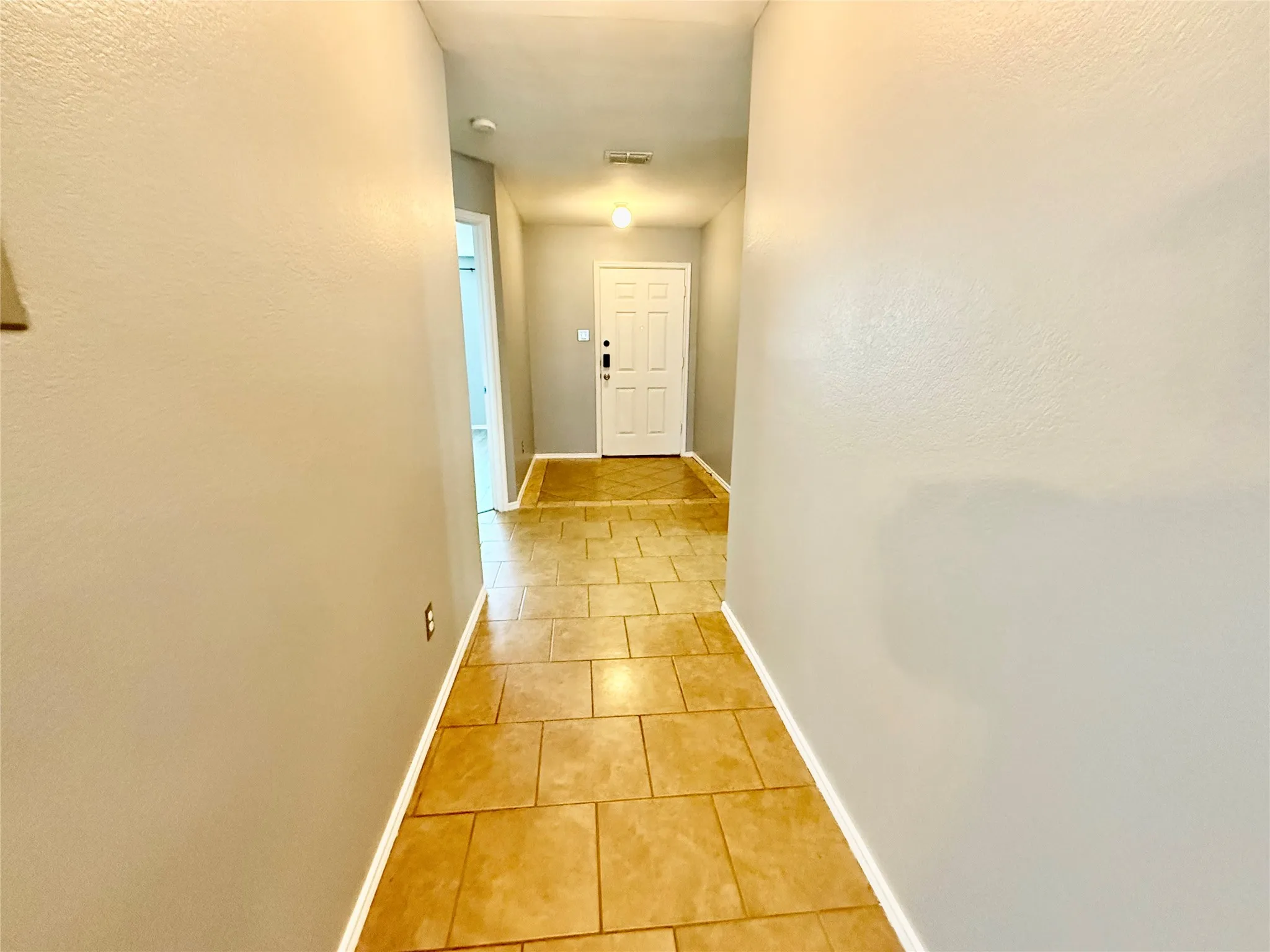 Tile flooring extending through the entry, neutral wall color, and white trim