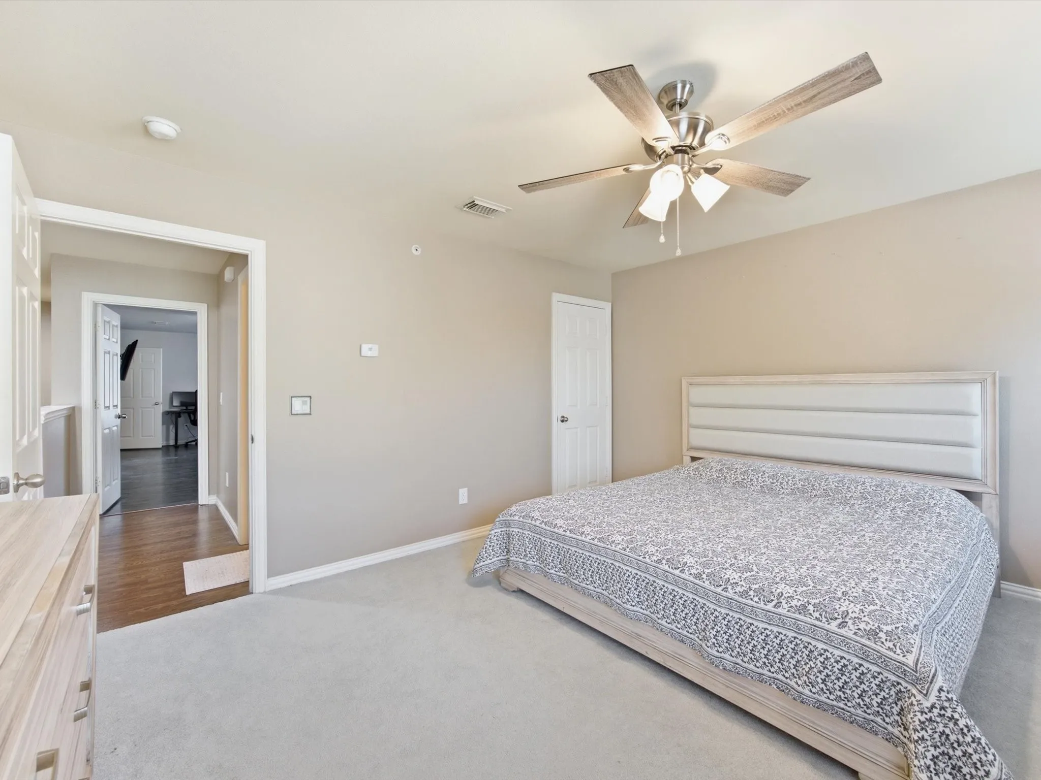 Plush carpeting, neutral wall tones, and a ceiling fan with integrated lighting
