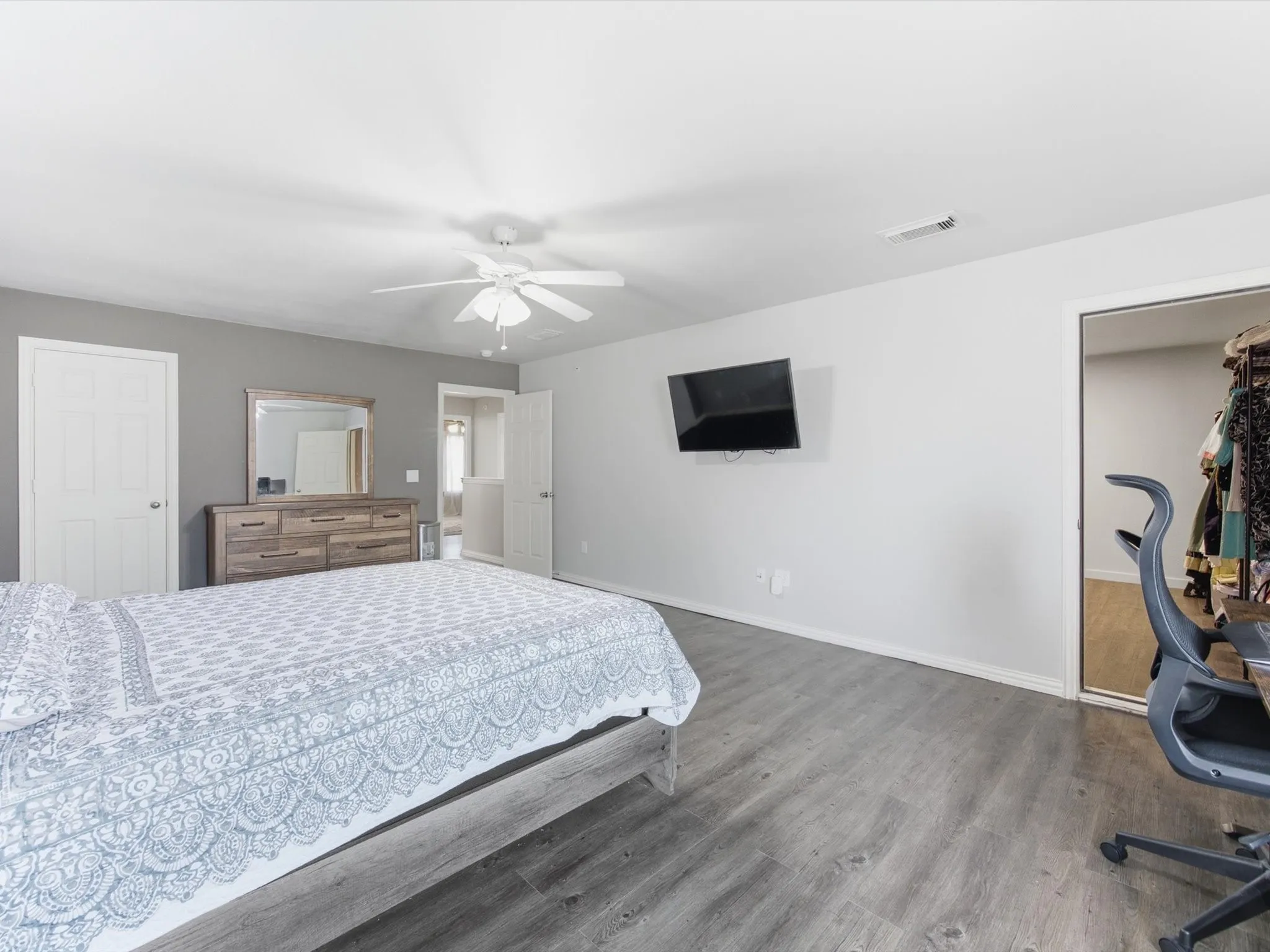 Wood-finish flooring, ceiling fan, and mirrored closet doors