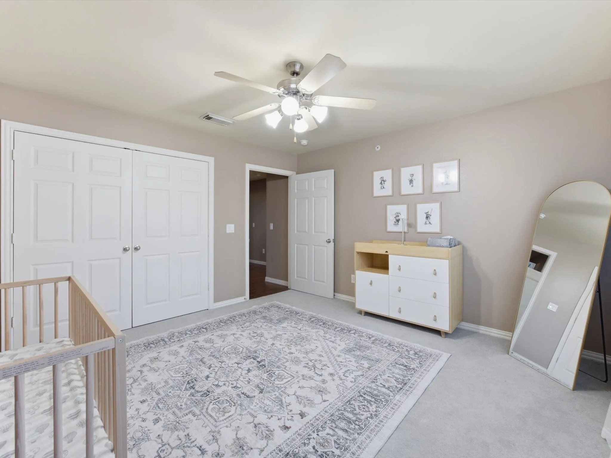 Ceiling fan with integrated lighting, neutral wall paint, white paneled doors, light carpet flooring, and a wide entryway