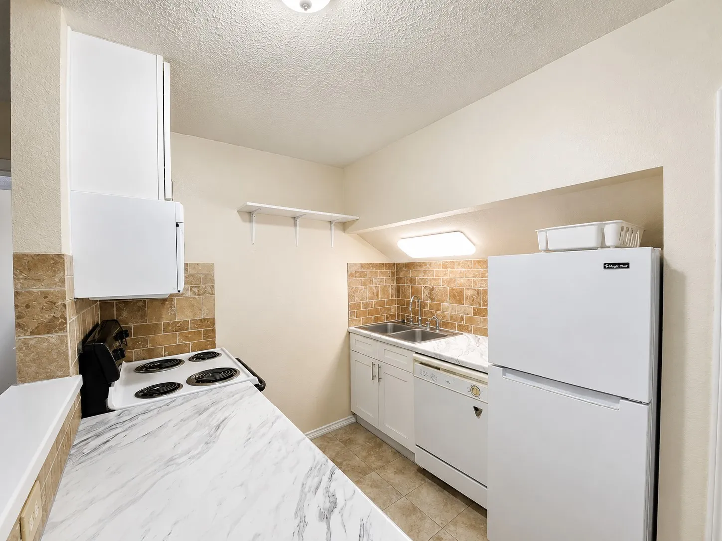 Kitchen featuring a white range, white refrigerator, white dishwasher, dual basin sink, and marble-look countertops