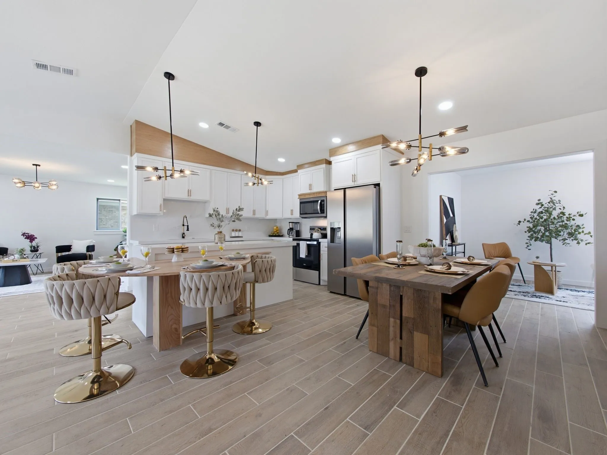 Kitchen island with seating, white cabinetry, integrated stainless steel appliances, wood-finish flooring, and recessed lighting
