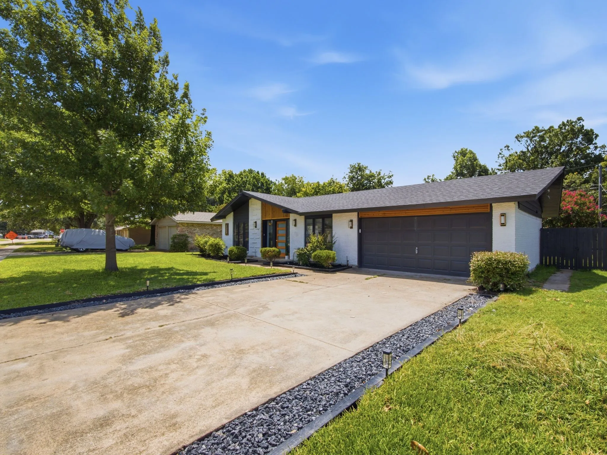 Contemporary exterior with a dark-pitched roofline and white siding