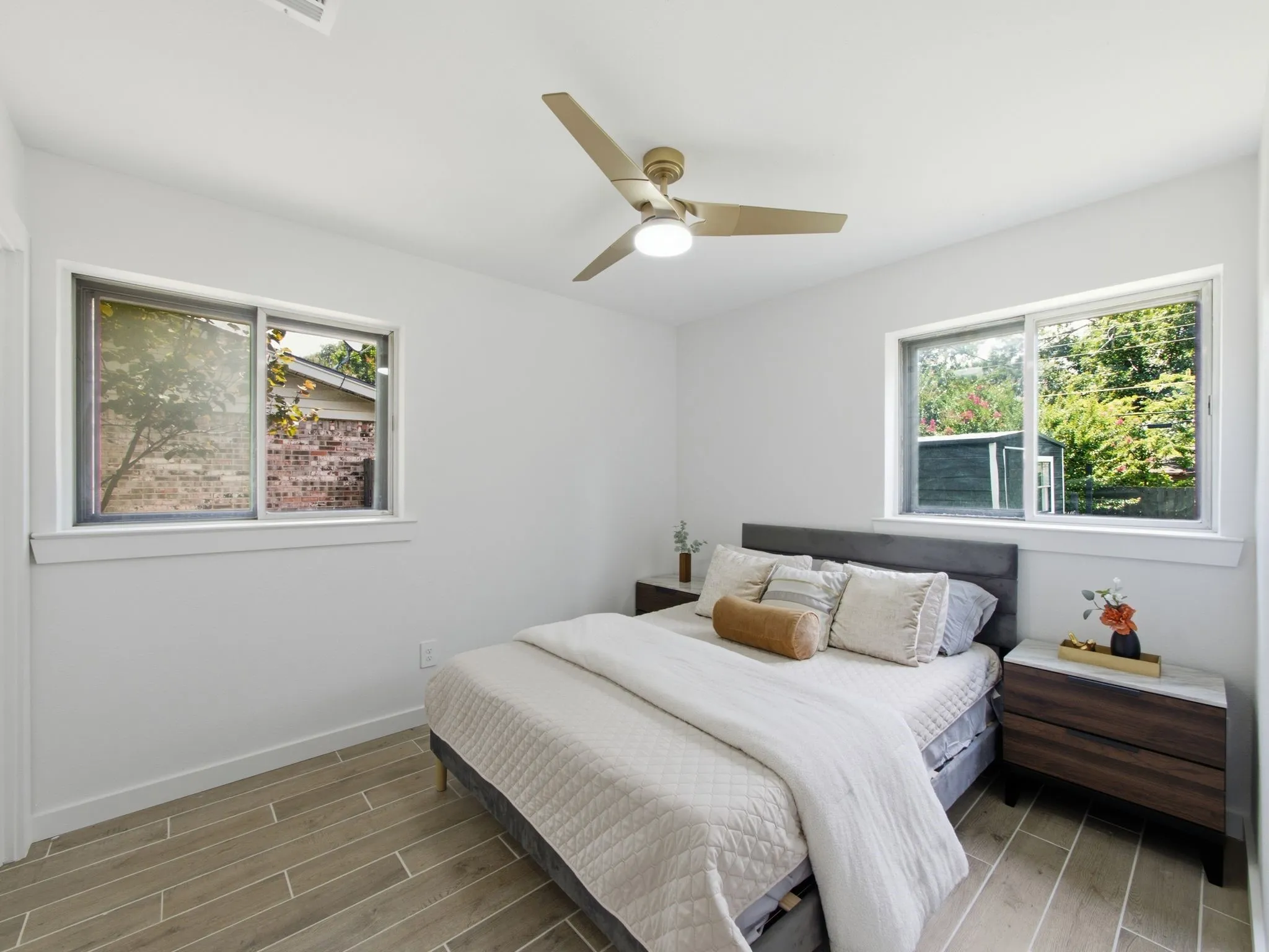 Wood-finish flooring, two windows, recessed lighting, and a ceiling fan with integrated lighting