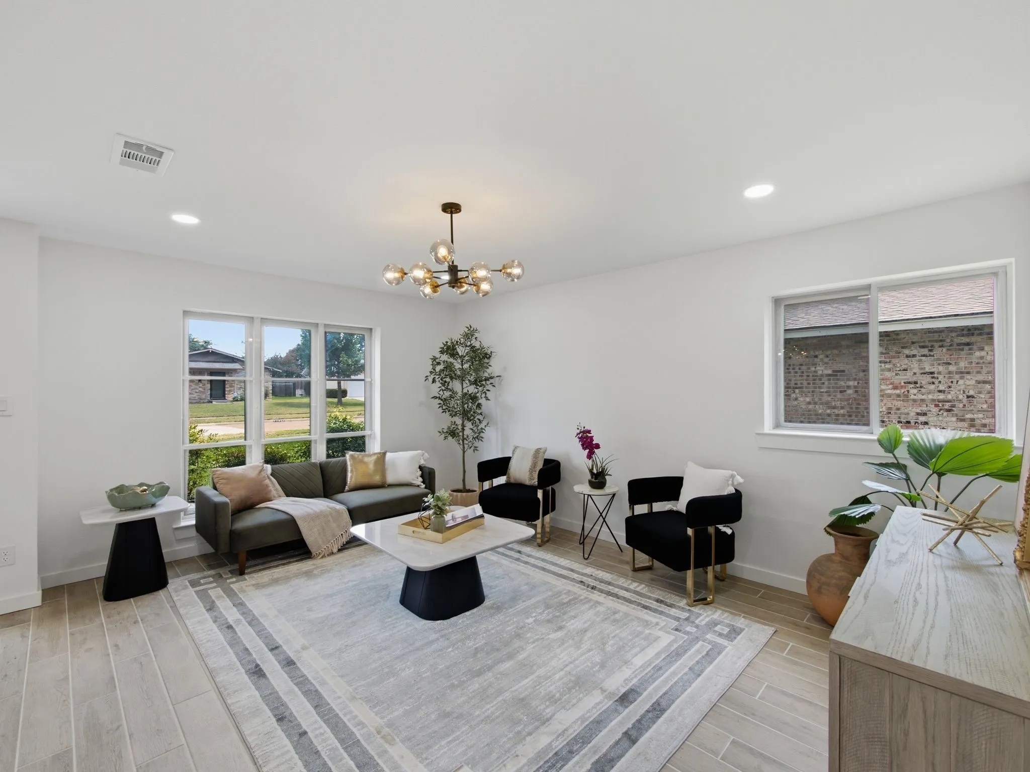Recessed ceiling lighting, wood-finish flooring, multiple windows, and a contemporary chandelier