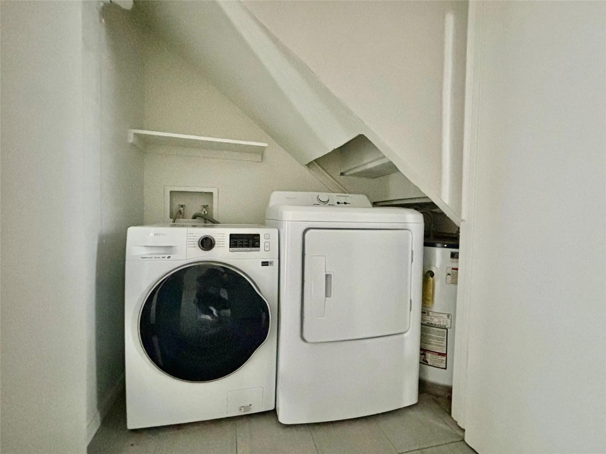 Dedicated laundry area with a utility shelf and wood-finish flooring