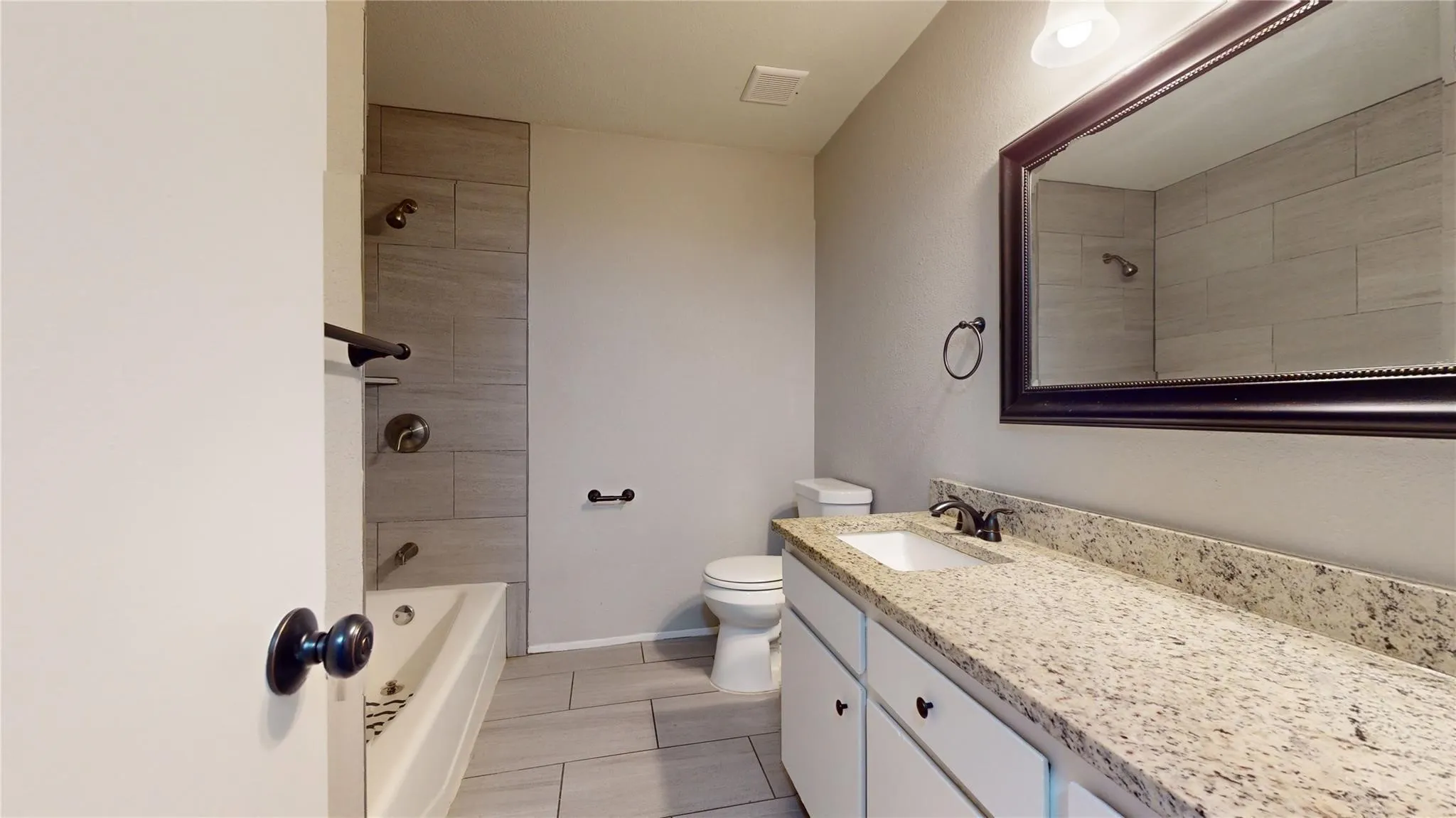 Extended vanity with a light-toned countertop, under-mount sink, and dark-finished faucet