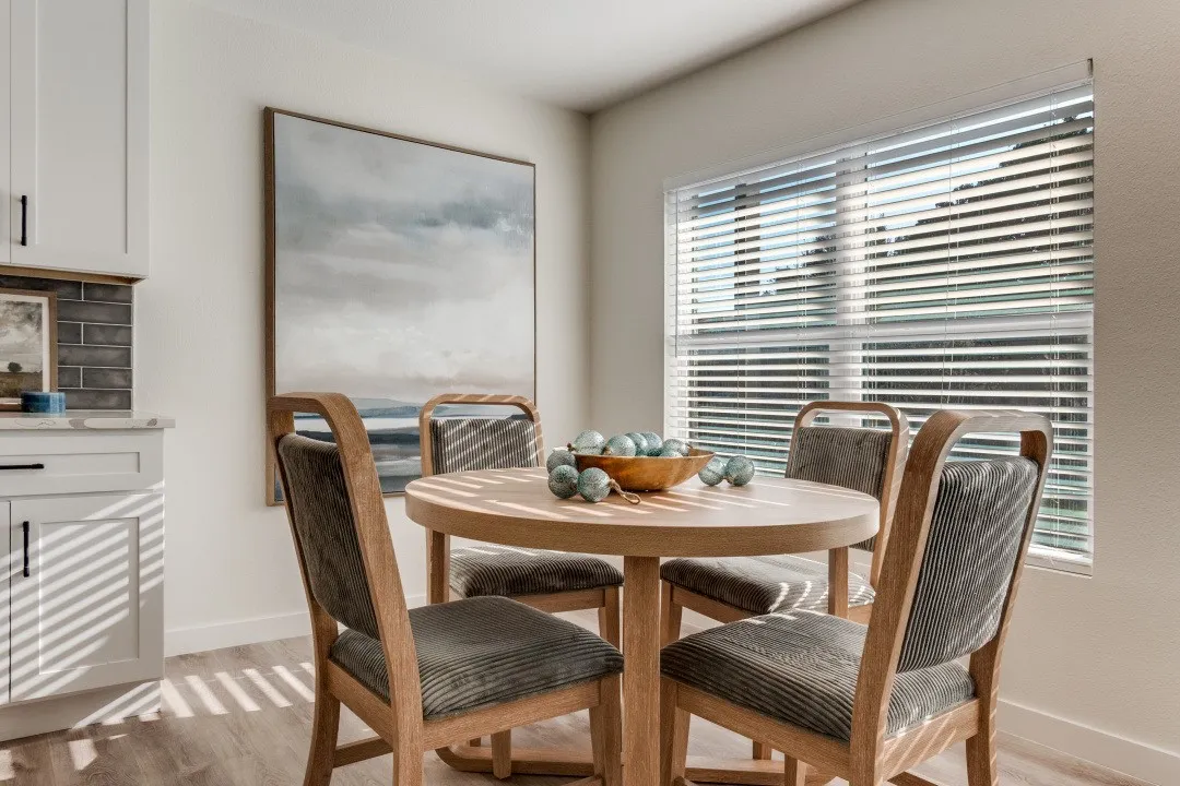 White cabinetry with black hardware, subway tile backsplash, wood-finish flooring, and a large window with blinds