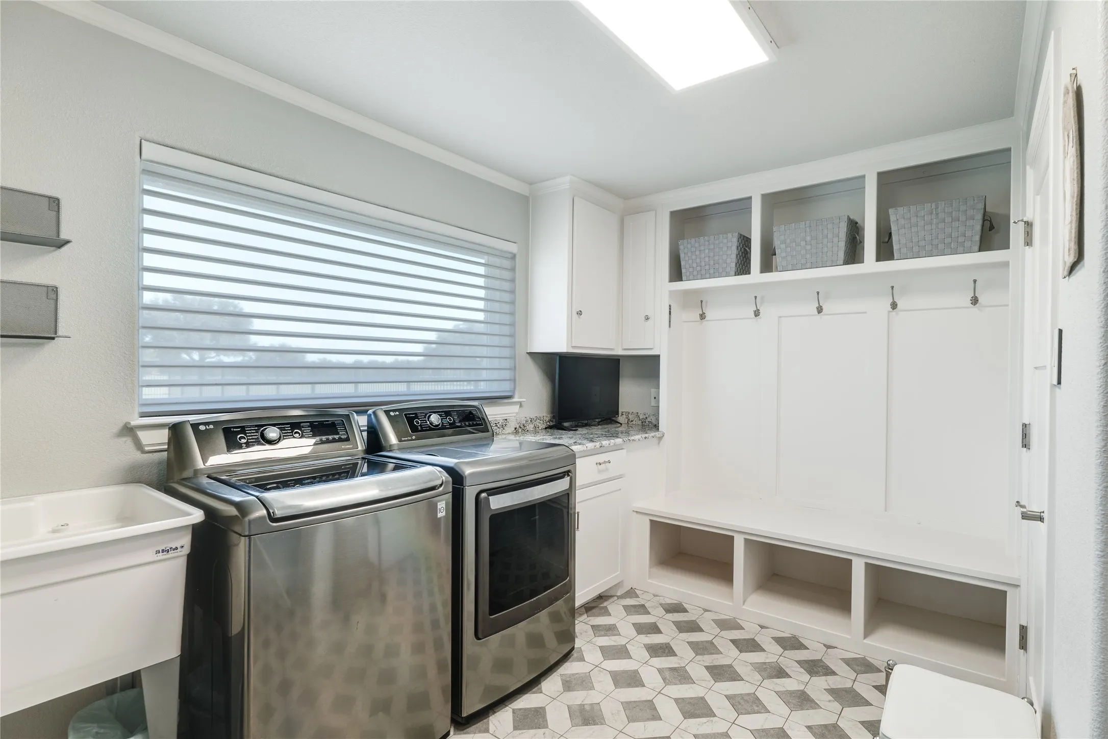 Laundry room has a sink and lots of storage