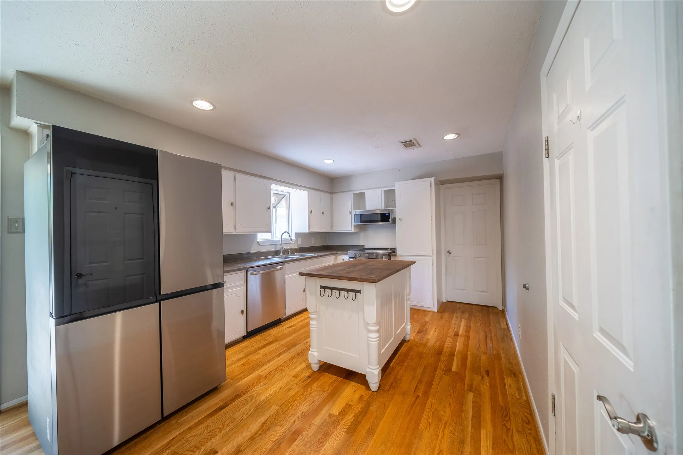 The kitchen is located at the back of the home with views to the back yard. The refrigerator features a beverage center, located inside the black panel door.