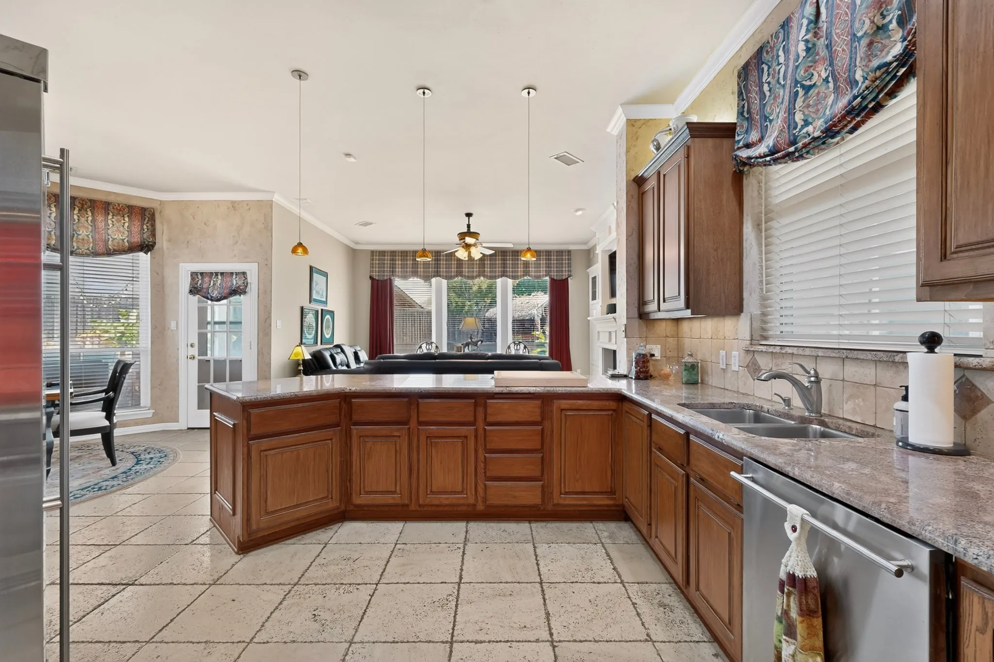 Kitchen featuring a central island, wood-finish cabinetry, stone countertops, and tile flooring