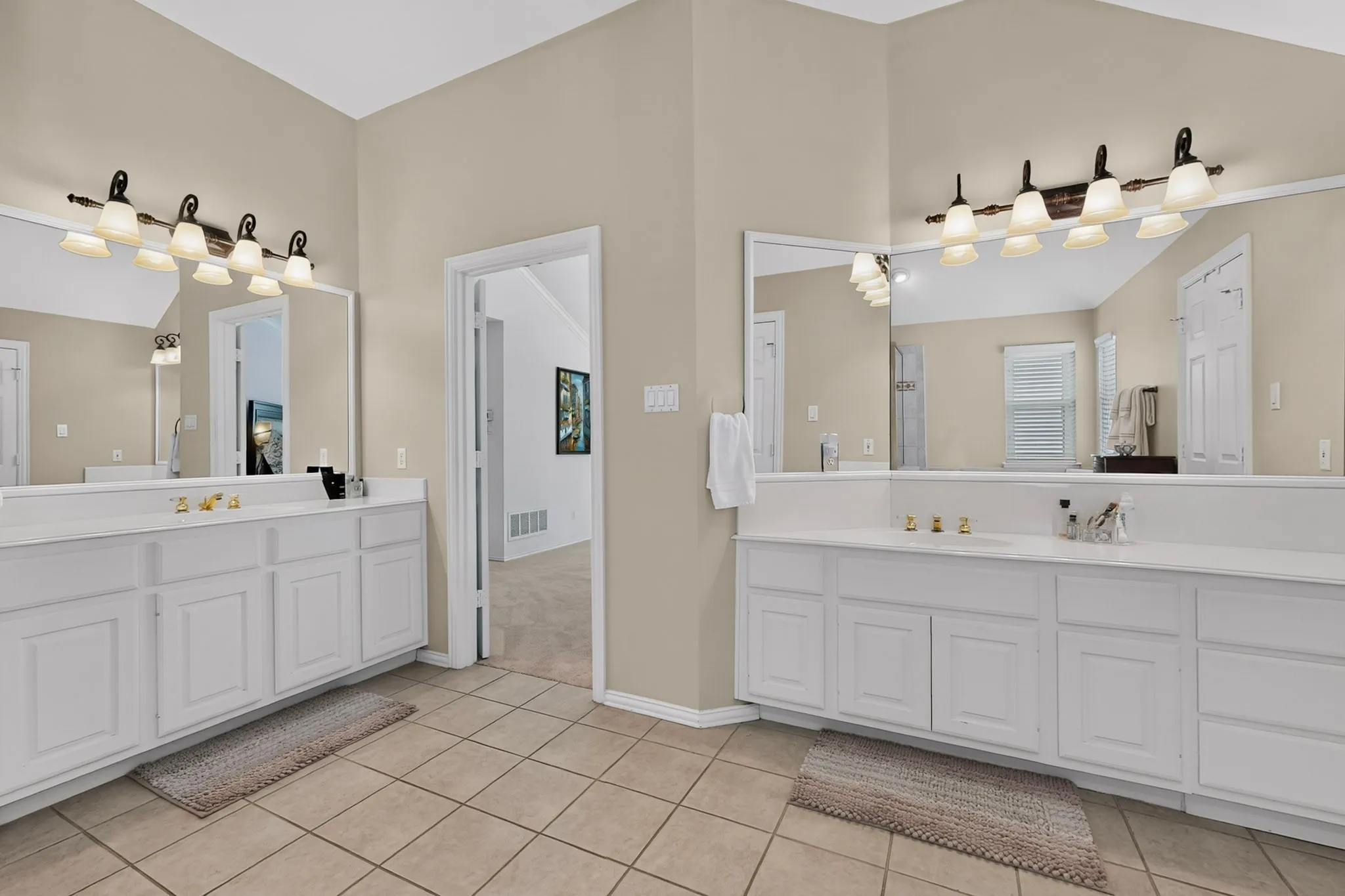 Dual vanity areas featuring white cabinetry and light-toned countertops