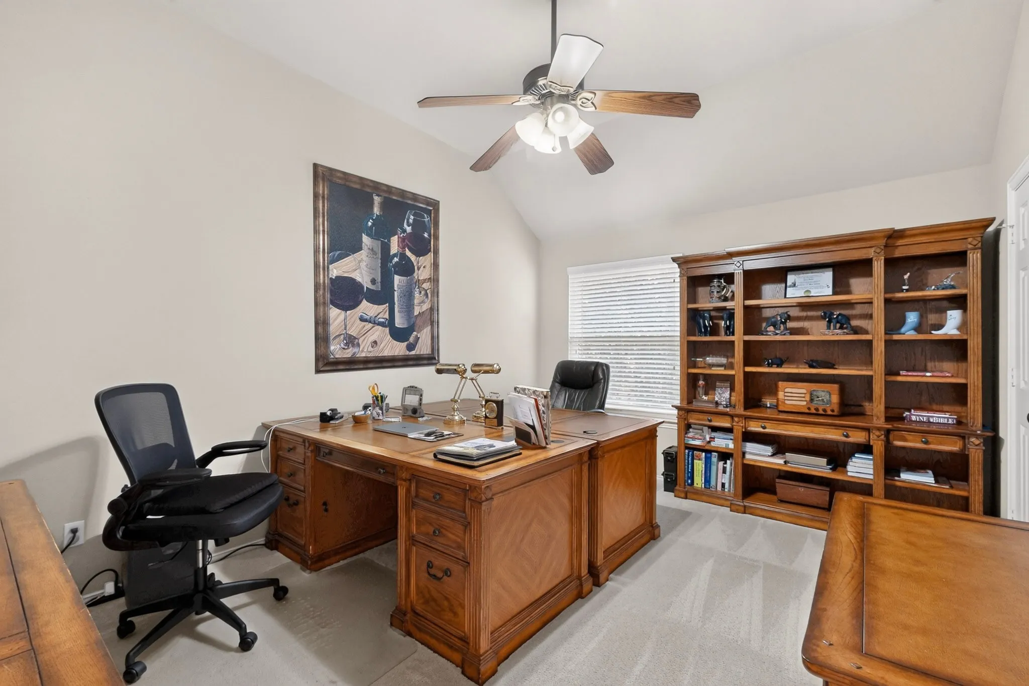 Vaulted ceiling with a ceiling fan, light-toned walls, and soft carpet flooring