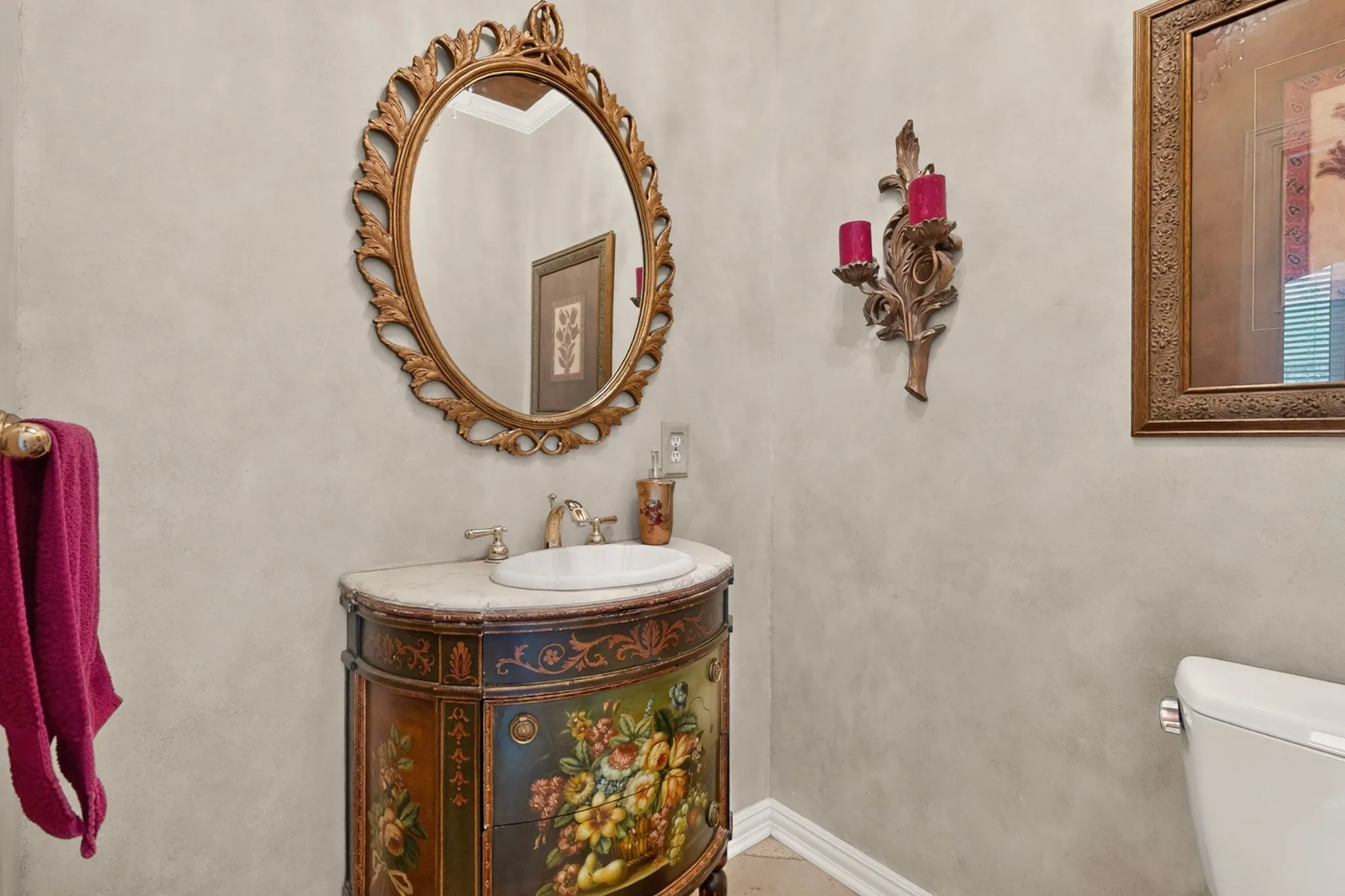 Ornate framed mirror over a console vanity with a built-in basin and brass-tone faucet