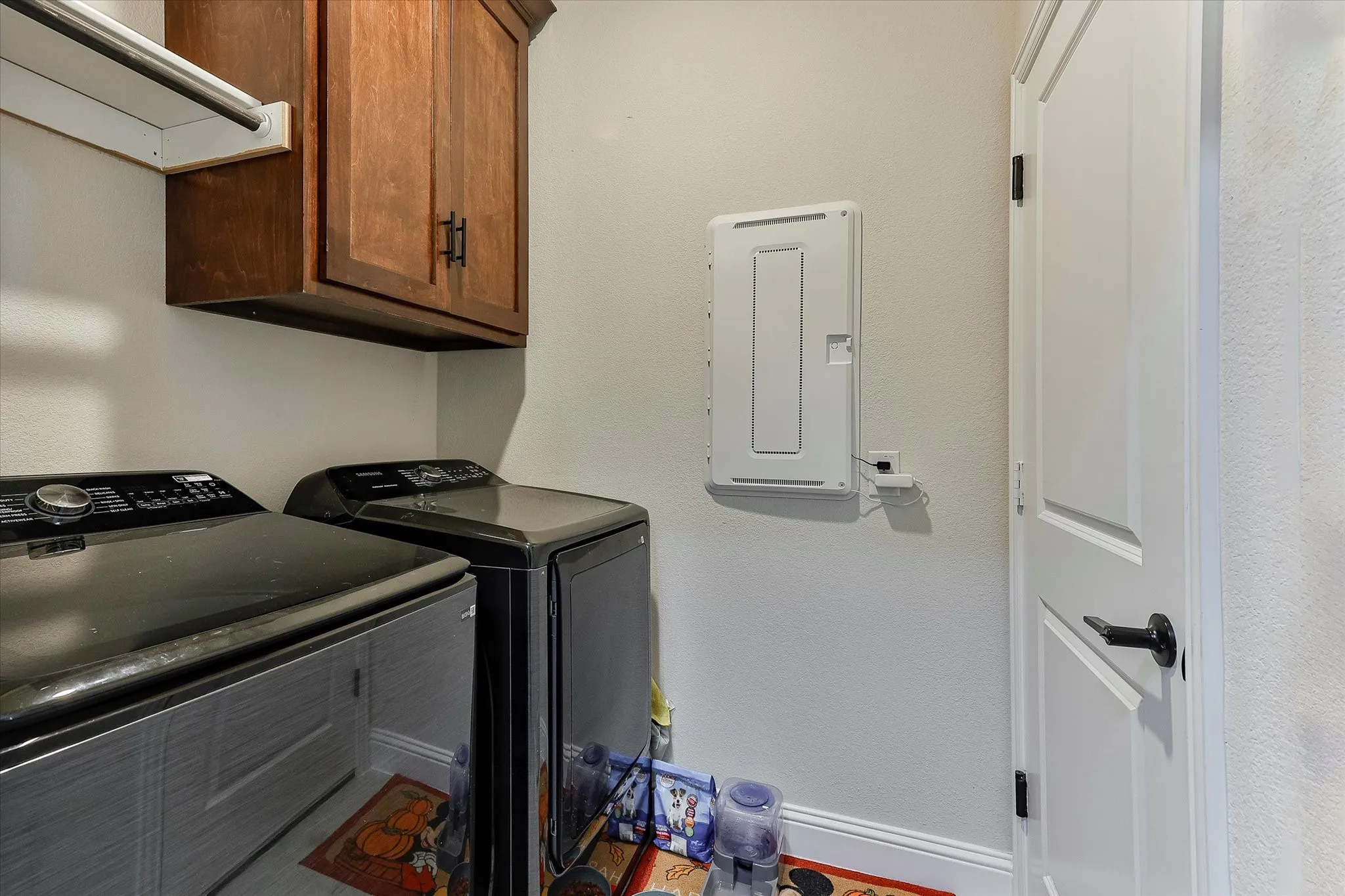Dark wood-finish cabinetry, white wall paint, and a white interior door with black hardware
