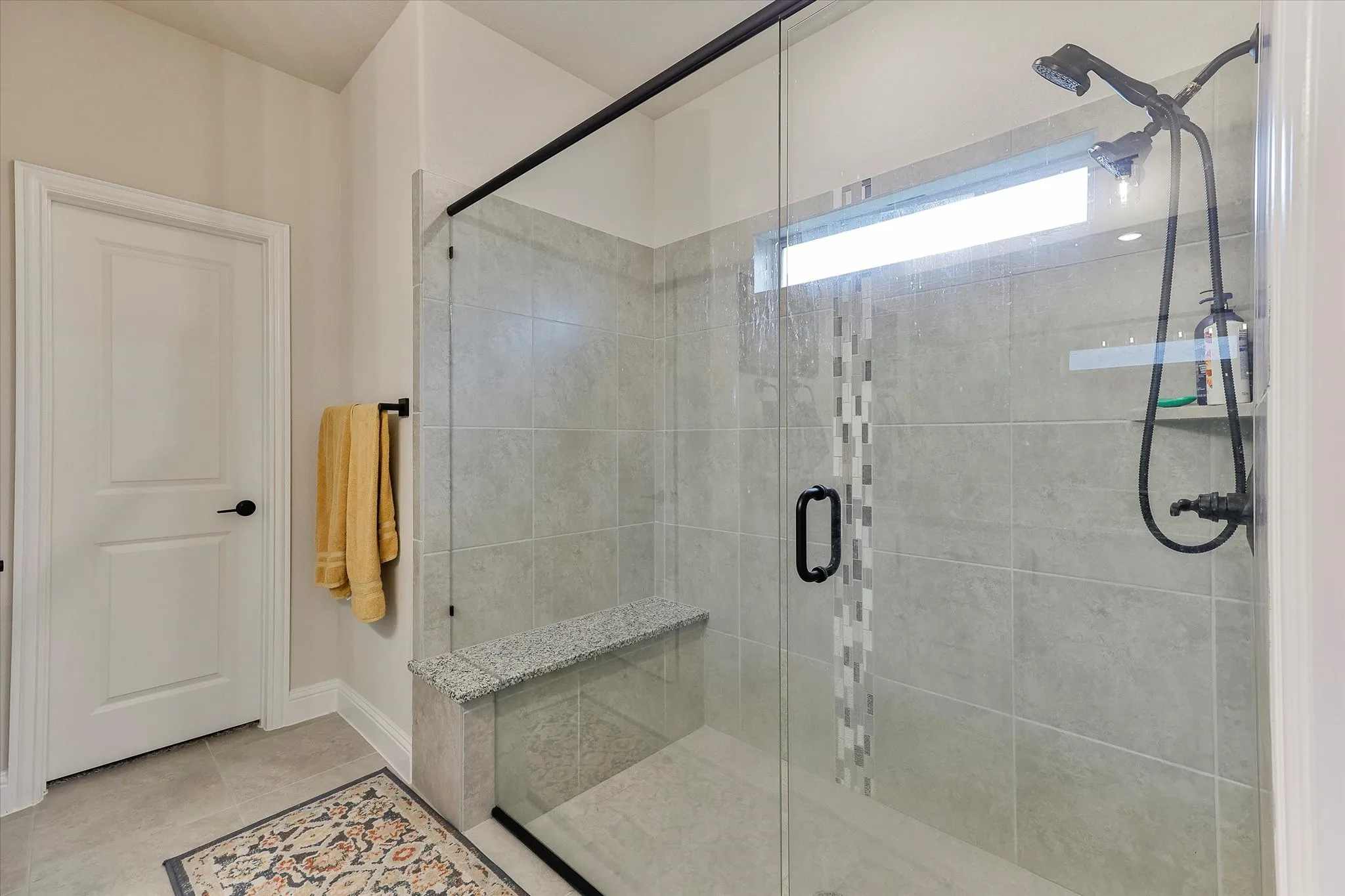 Walk-in shower with clear glass enclosure and black hardware