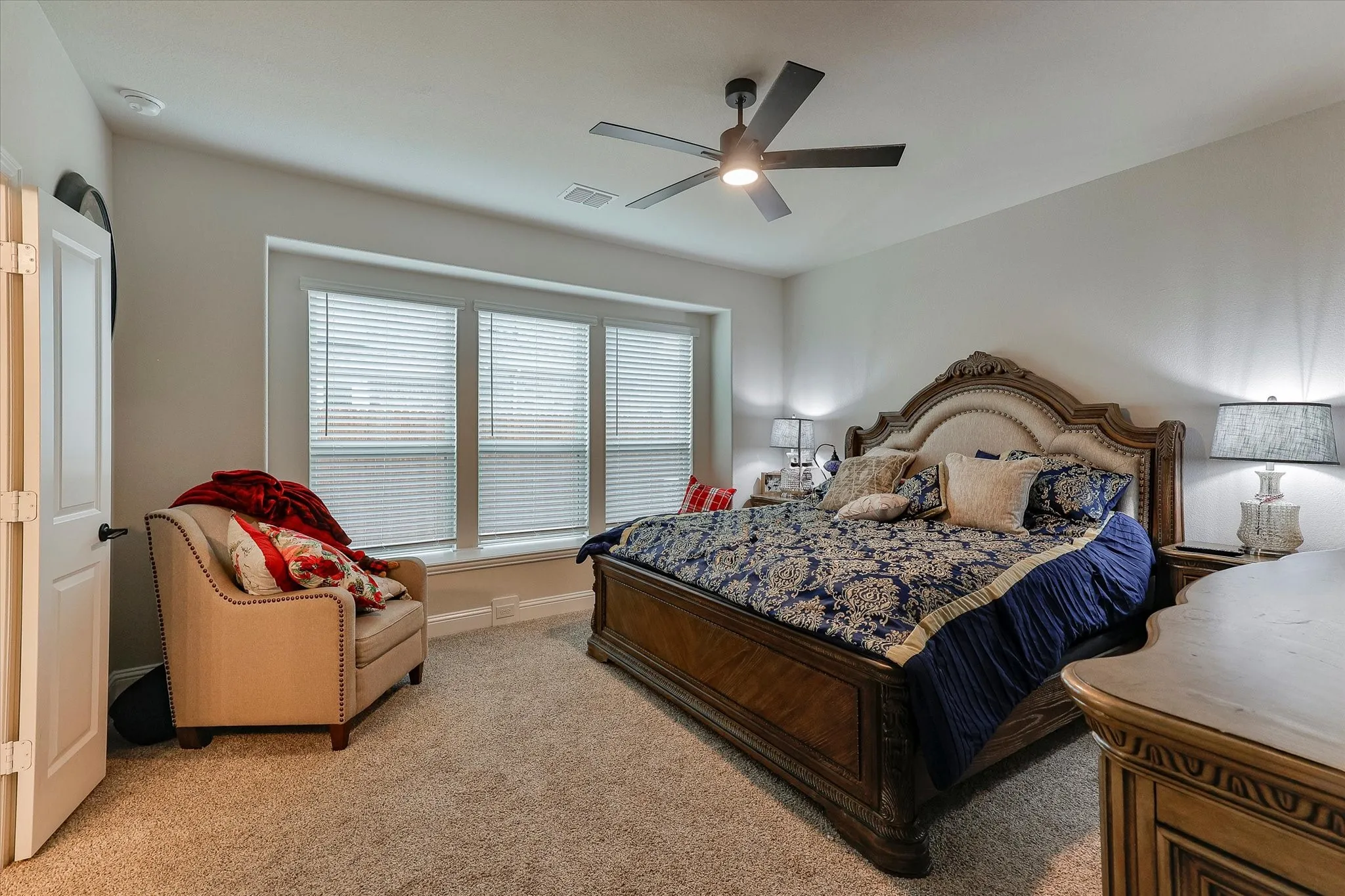 Recessed lighting, ceiling fan with light fixture, multiple windows with blinds, and carpet flooring