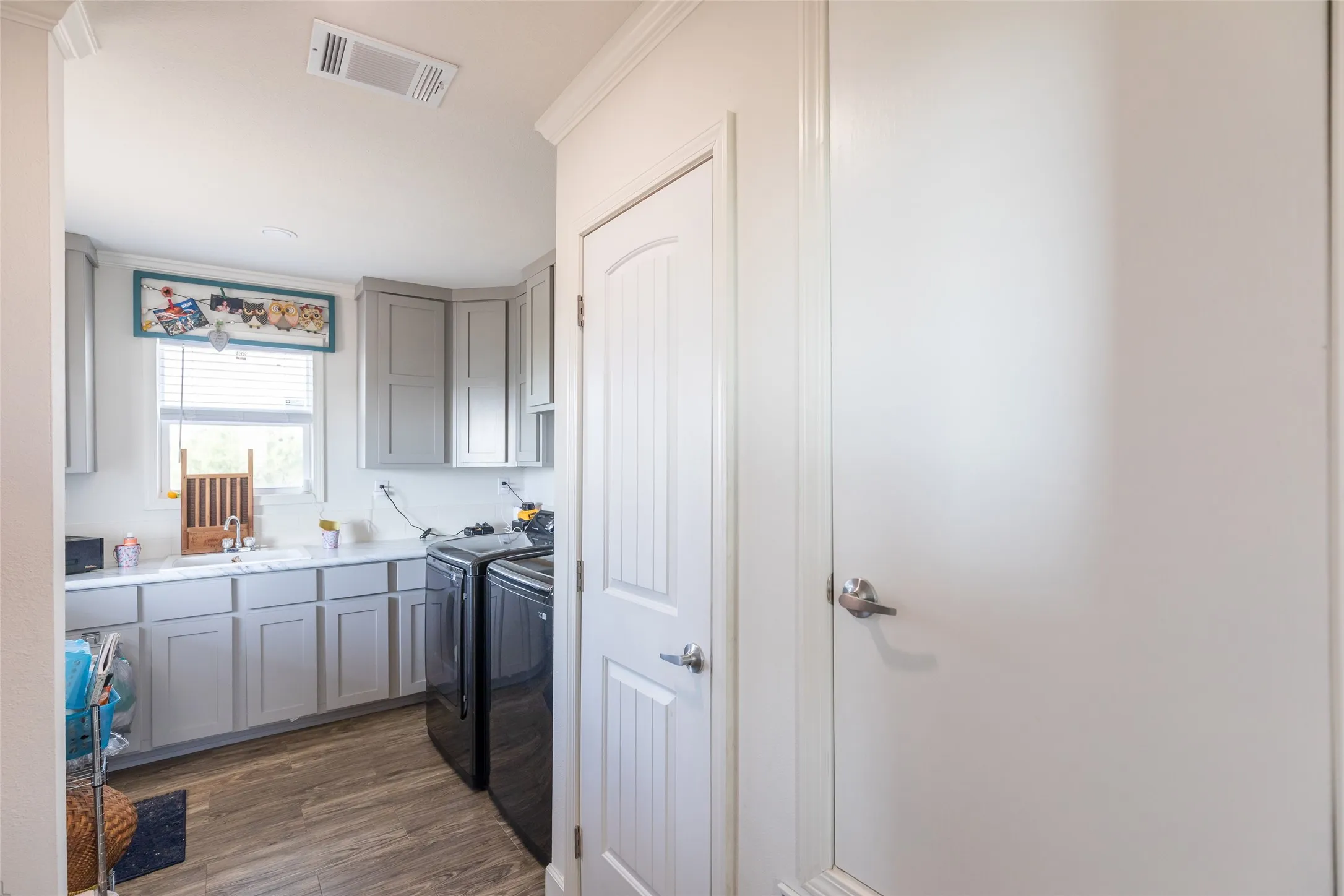 Laundry room with Washer and Dryer set-up, plus a sink and cabinet space! Laundry Room also has a backdoor to access the covered back porch!