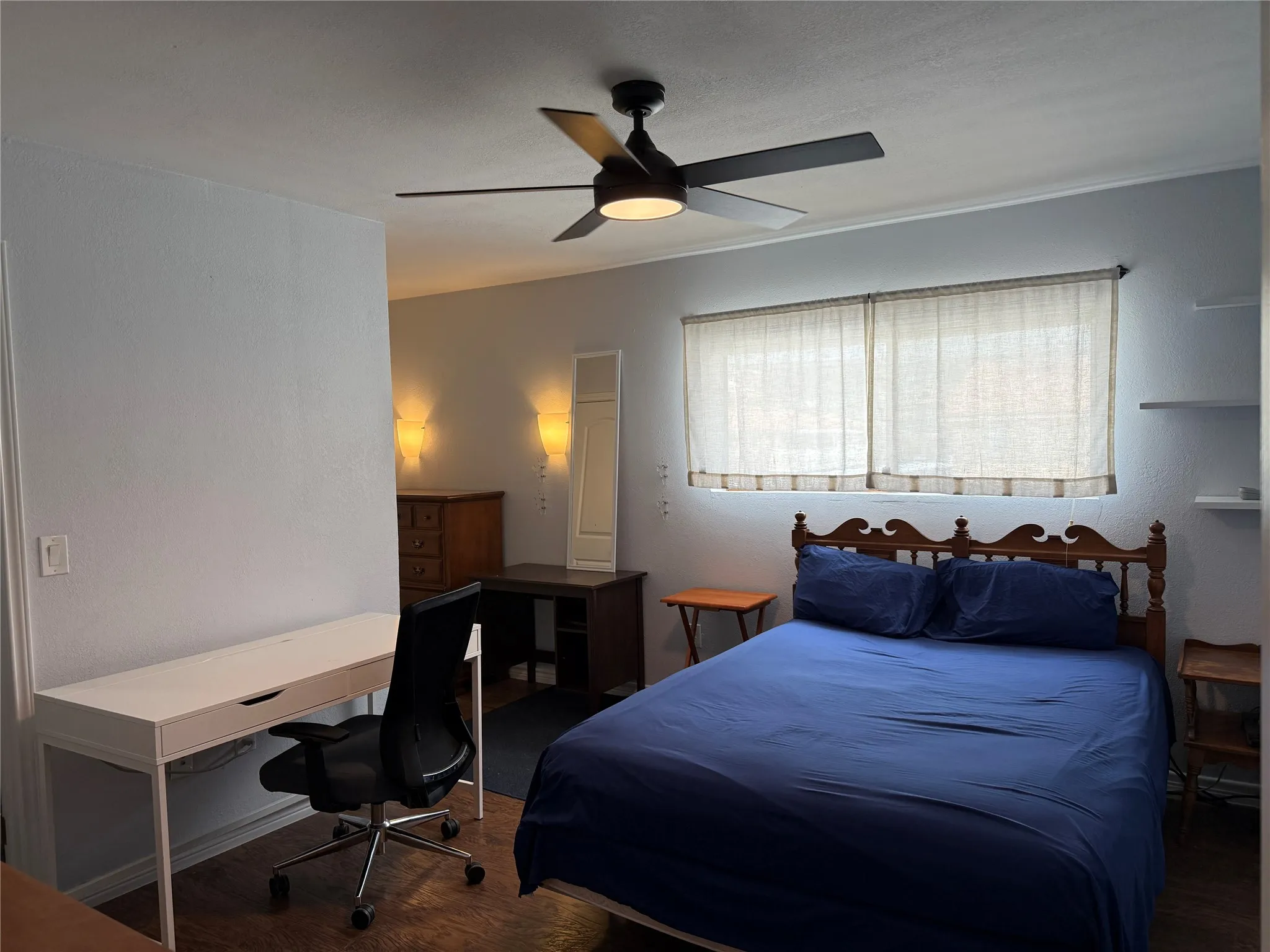 Bedroom featuring a ceiling fan, wood-finish flooring, and window coverings