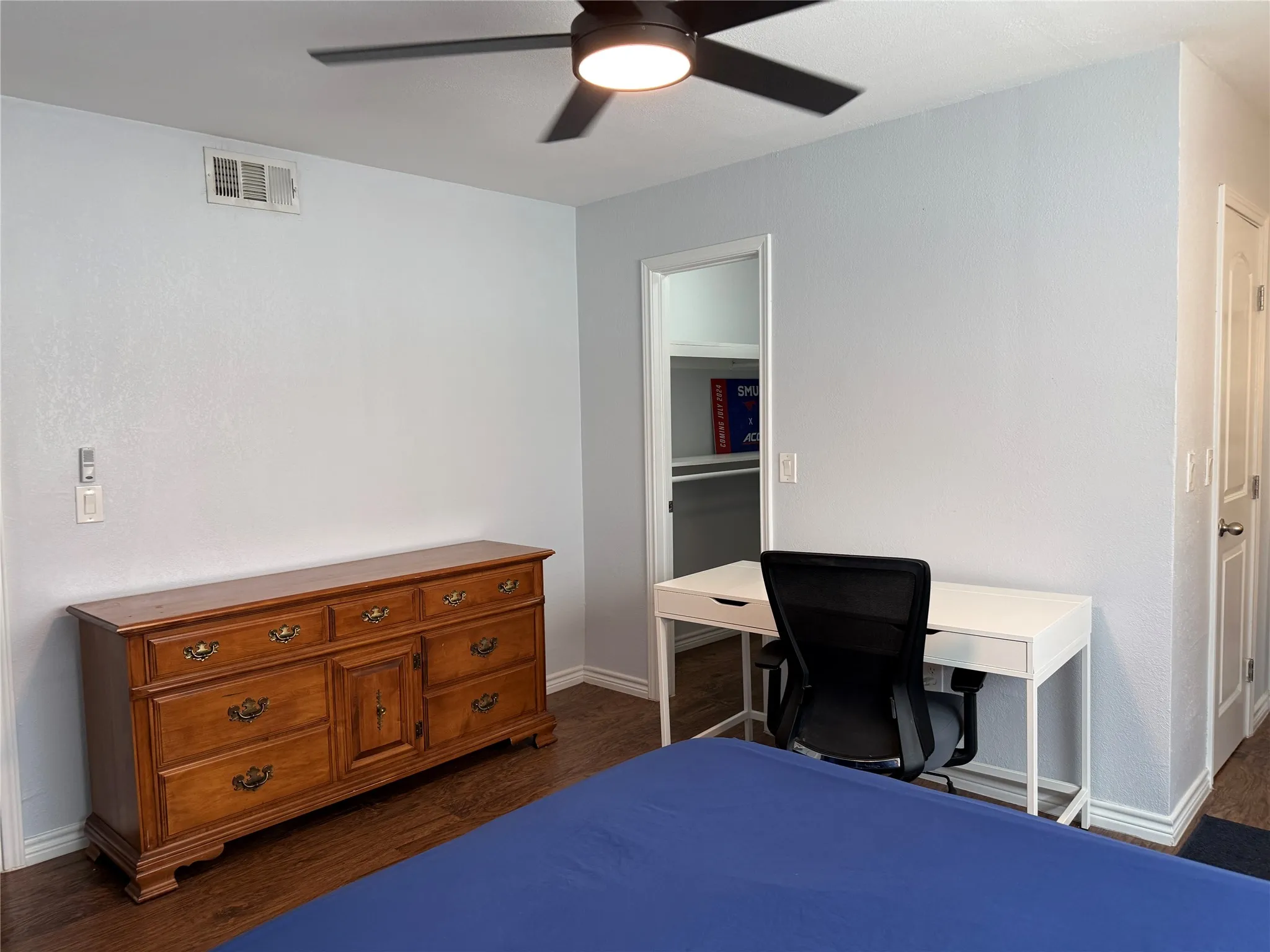 Spacious room featuring wood-finish flooring, a contemporary ceiling fan, and painted walls