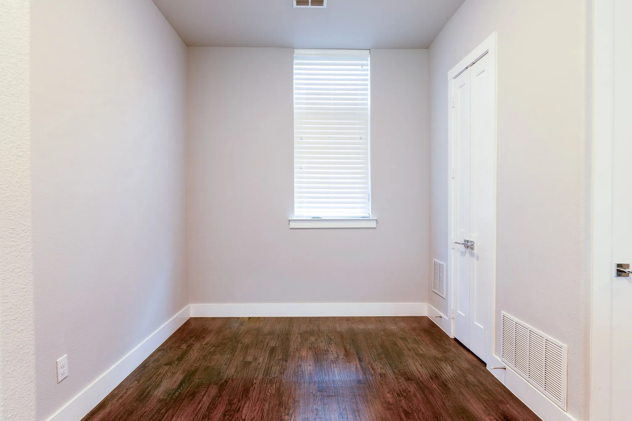 Dining area featuring wood-finish flooring, a single window with blinds, pantry and light neutral wall finishes