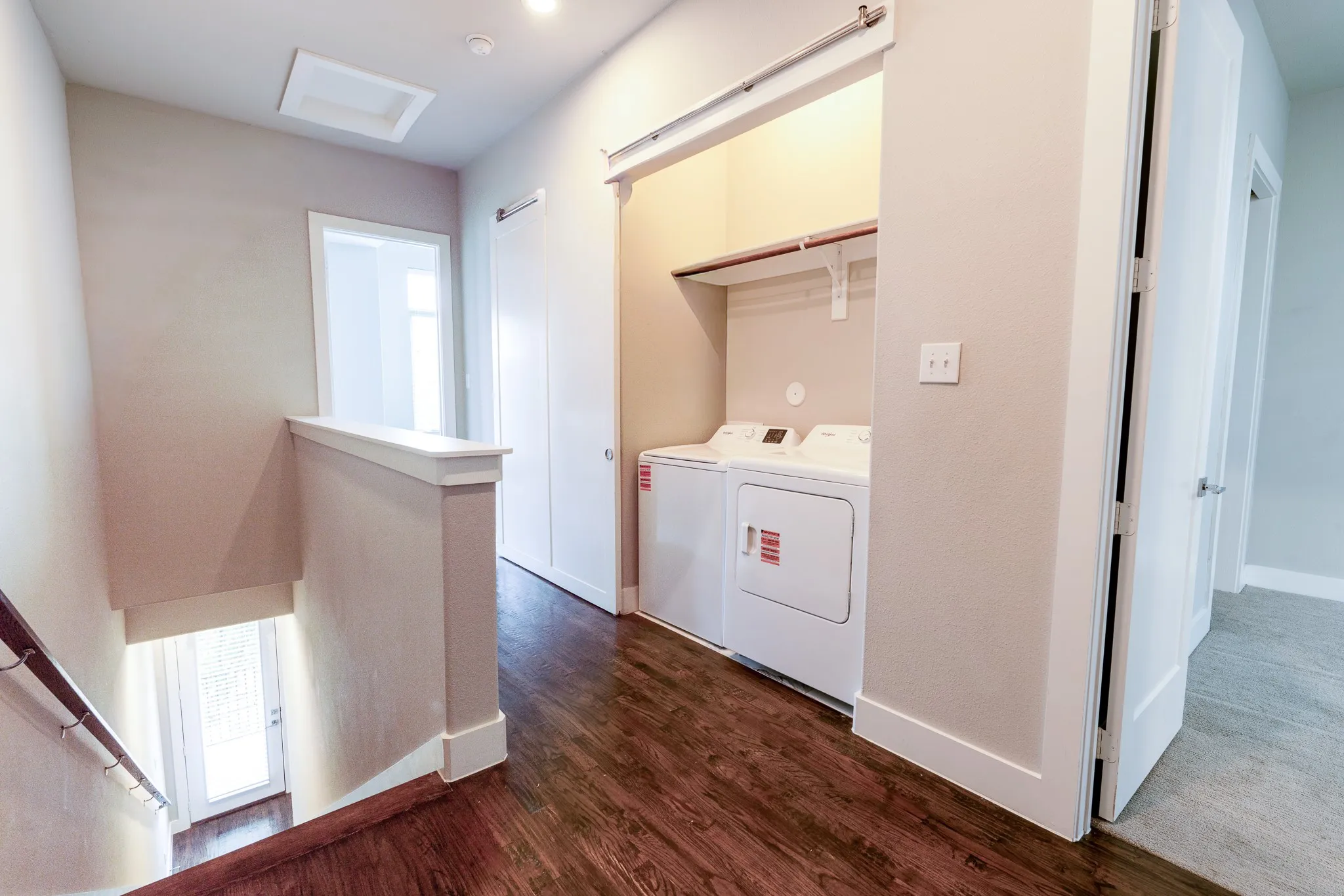 Hallway featuring wood-finish flooring, recessed lighting, and a built-in laundry area with shelving