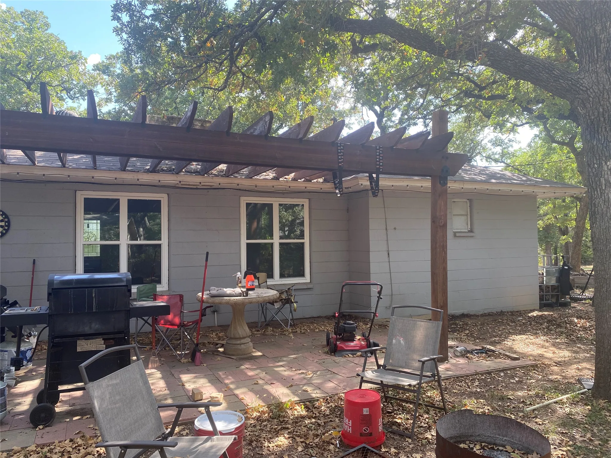 Trees shade back patio with pergola