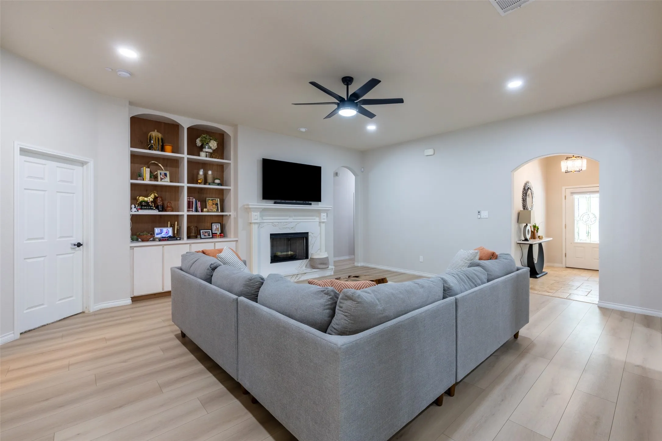 Living area featuring light wood-finish flooring, recessed lighting, and a ceiling fan