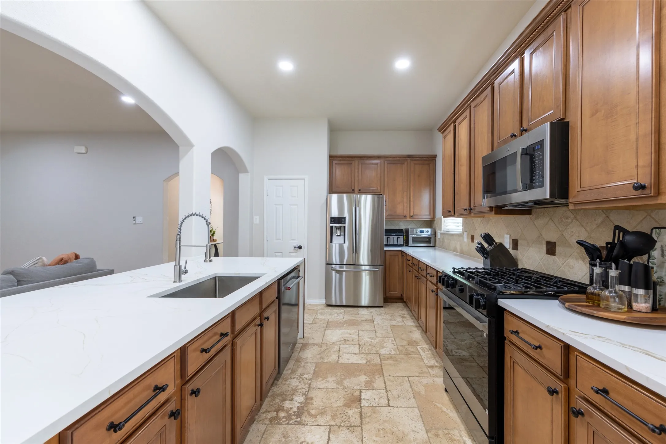Kitchen featuring a stainless steel refrigerator, microwave, and gas range