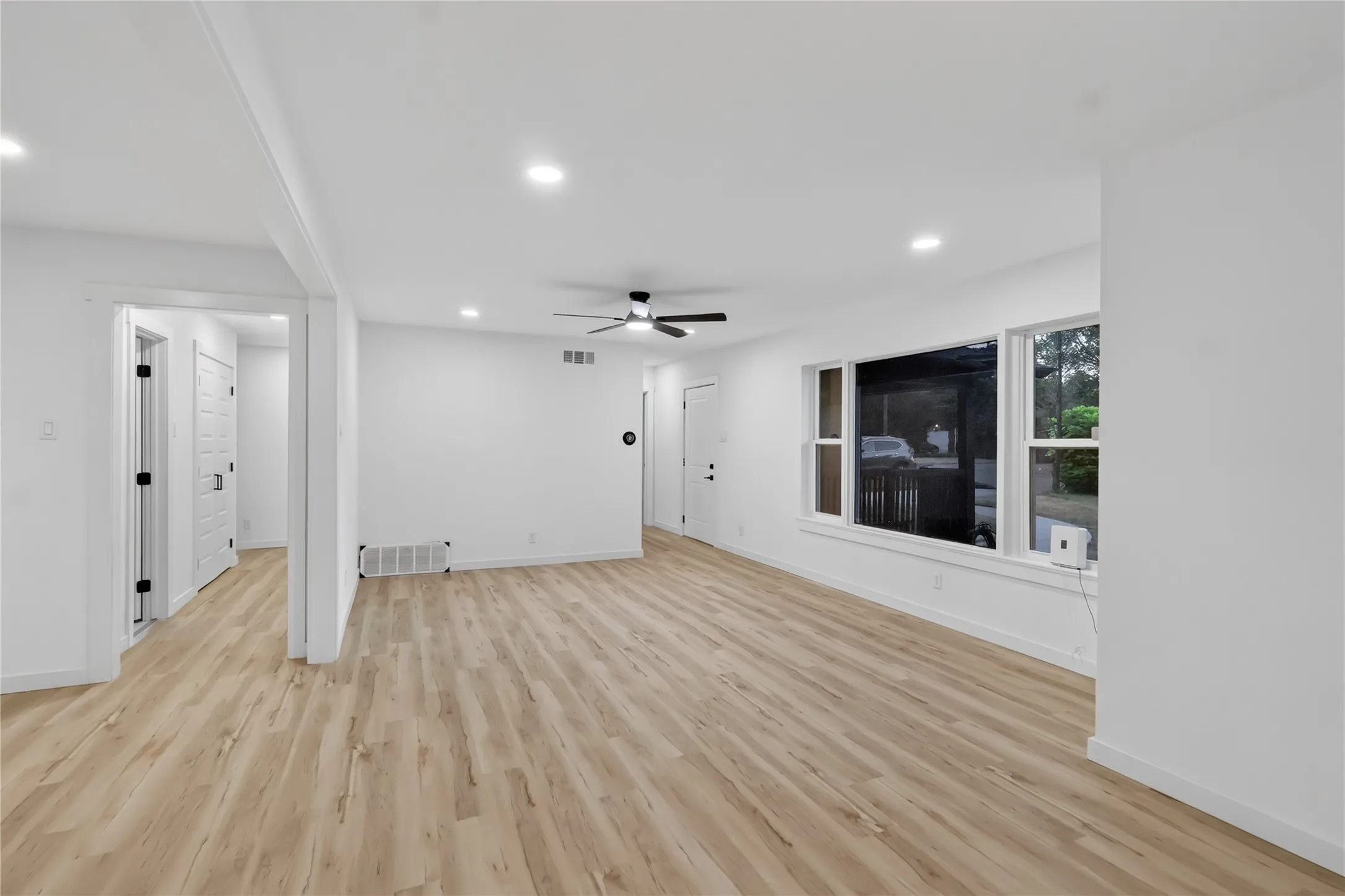 Recessed lighting throughout, wood-finish flooring, ceiling fan, and multiple windows providing natural illumination