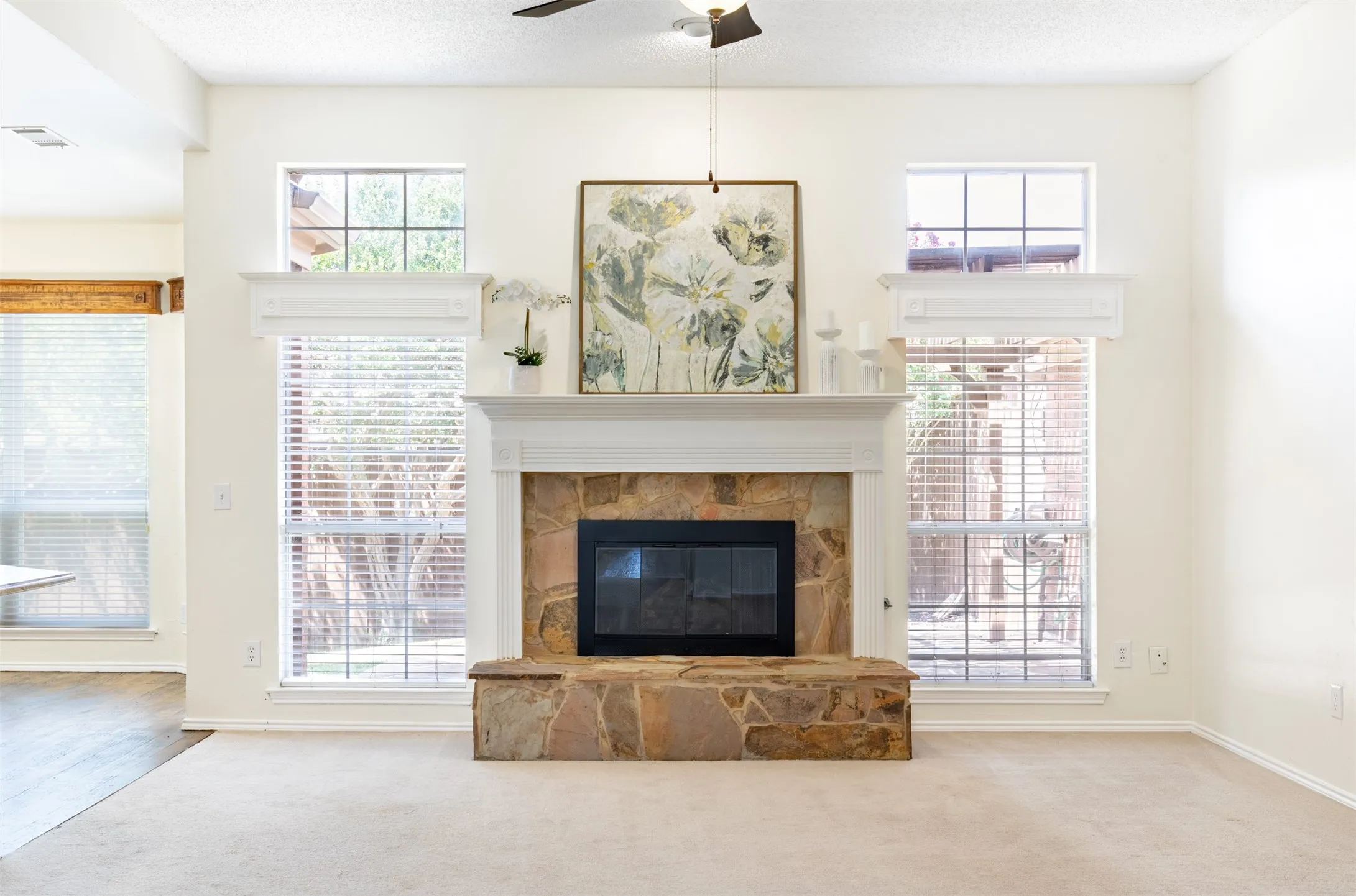 Living room anchored by a striking stone fireplace with mantel.