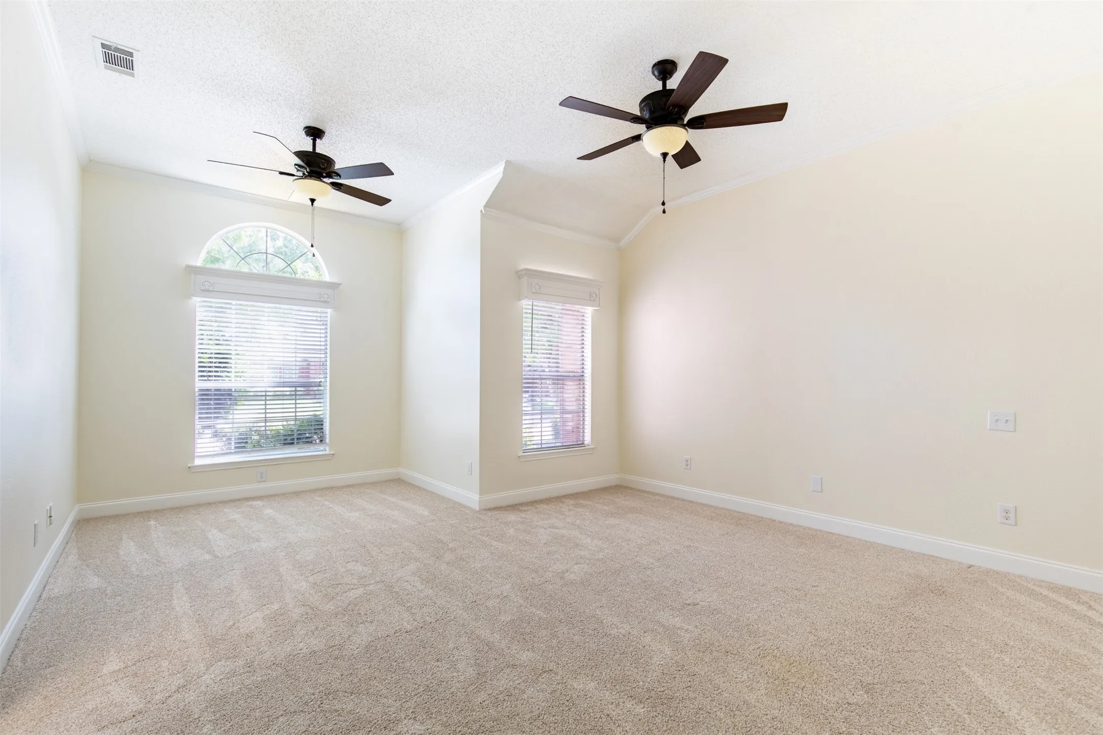 Expansive primary suite featuring 2 ceiling fans and bonus area, ideal for sitting room.