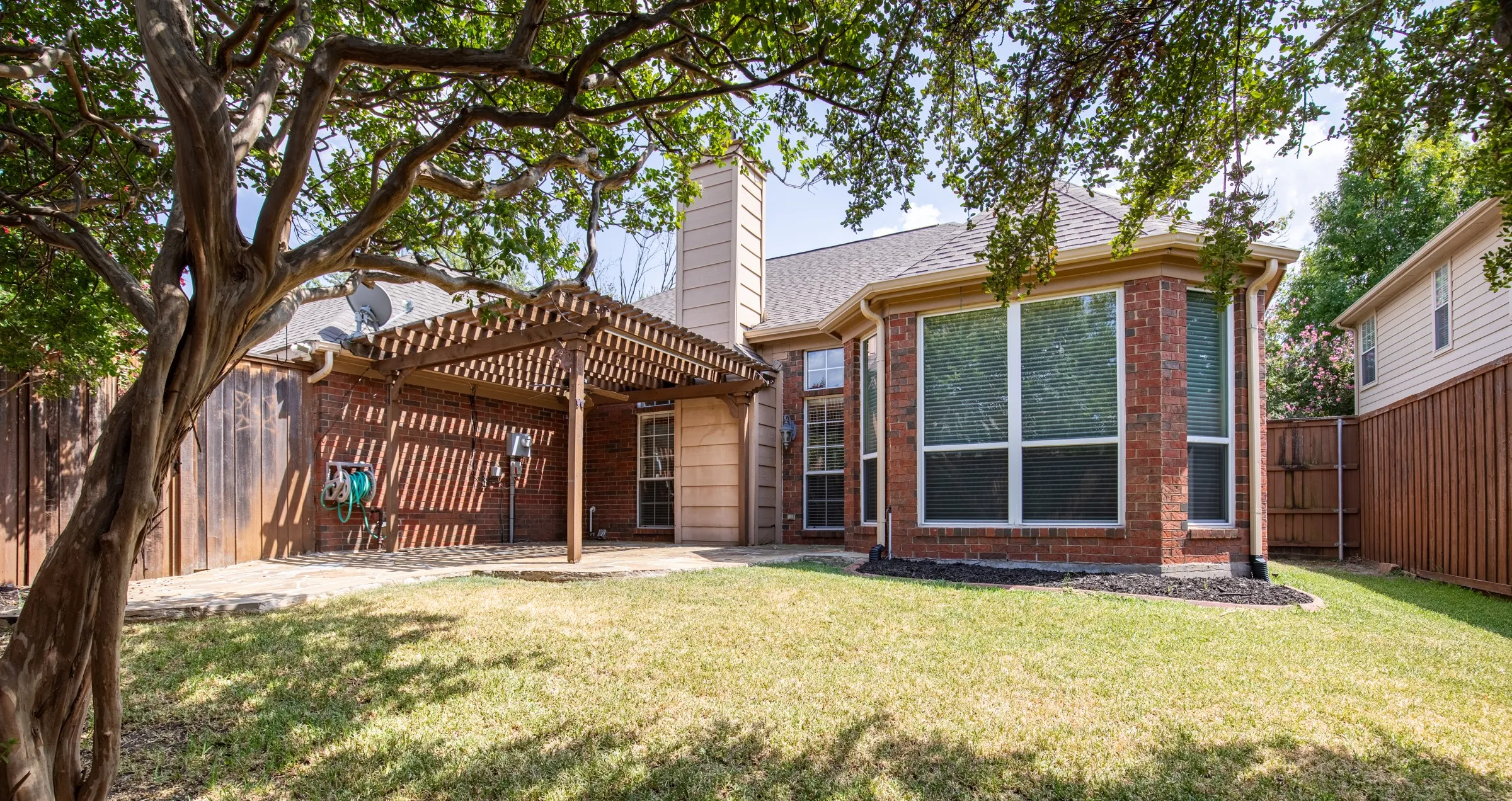 Backyard with mature shade trees.
