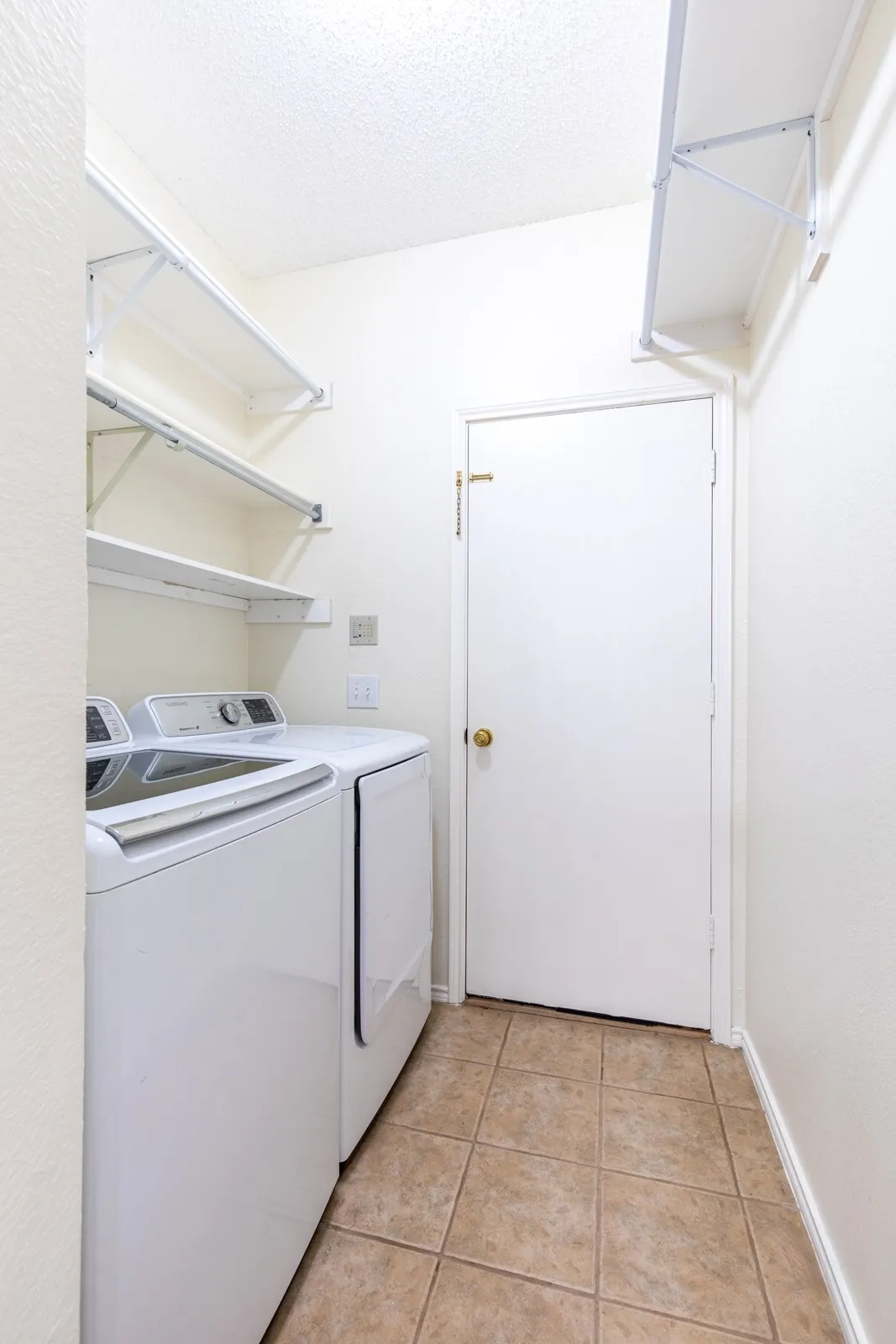 Laundry room with built-in shelving and washer/dryer that conveys.