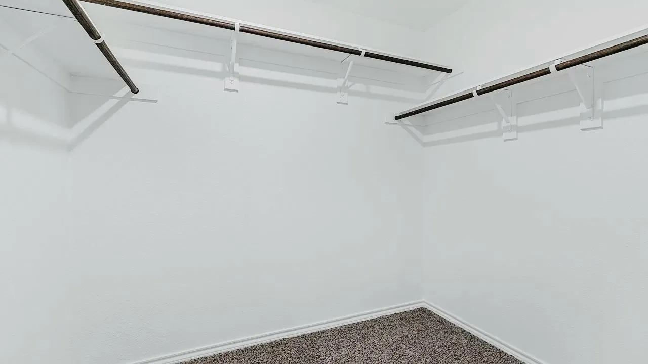 Wall-to-wall carpeting with light-toned walls and integrated shelving with garment rods