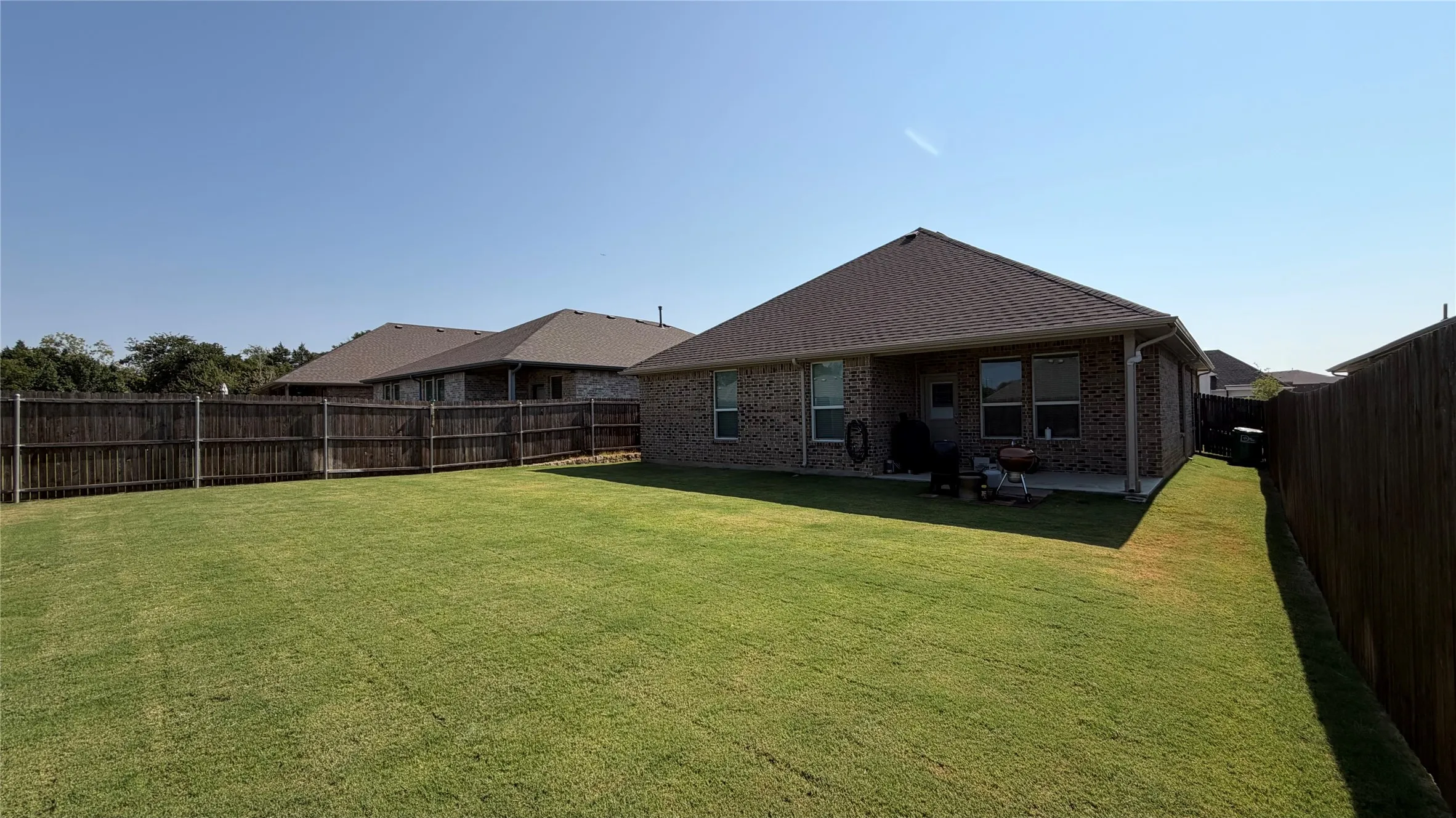 Expansive grassy lawn with wood privacy fencing