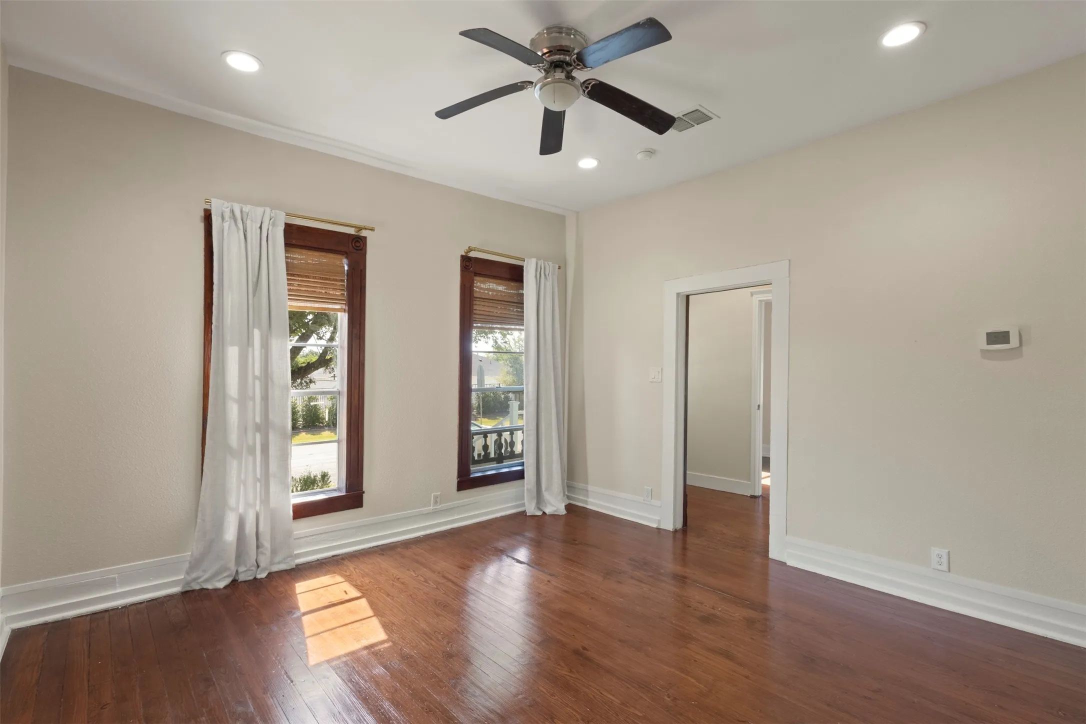 Hardwood flooring, recessed lighting, ceiling fan, crown molding, and a doorway with trim
